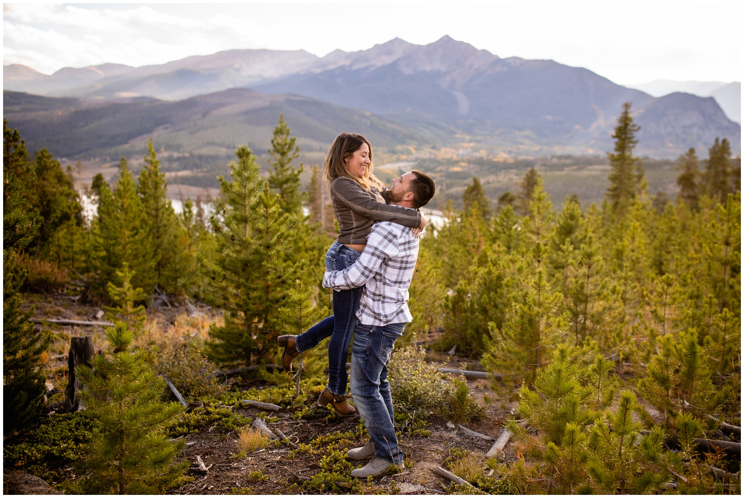 guy lifting his fiancé during Colorado mountain engagement photos at Sapphire Point in Breckenridge 