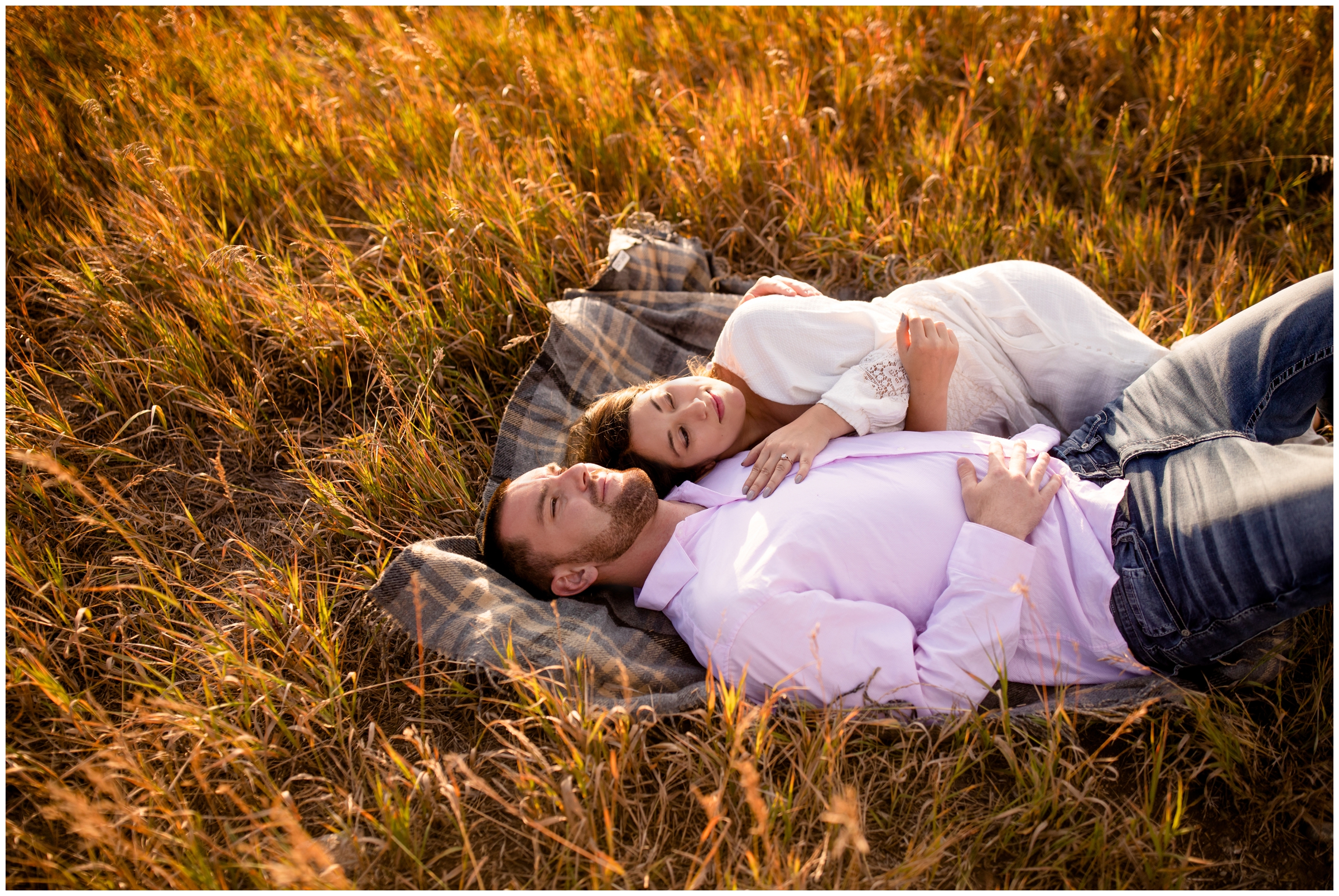 couple laying on a blanket in a field during their Colorado mountain engagement pictures in Breckenridge 
