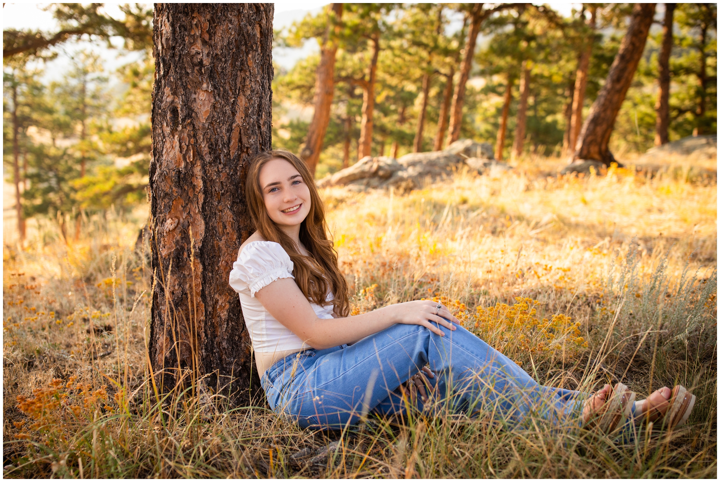teen girl leaning against tree during Colorado forest senior pictures in boulder CO
