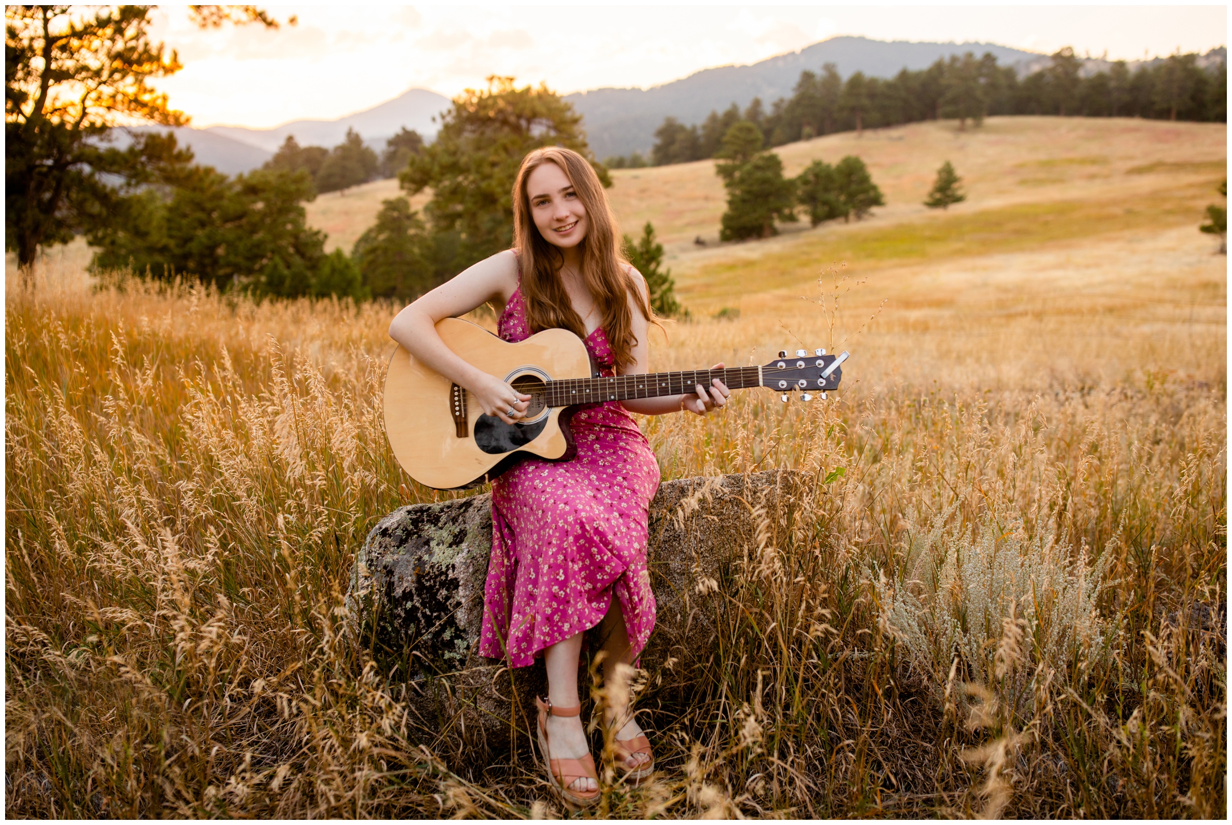 teen playing guitar with mountains in background during Boulder CO senior photos