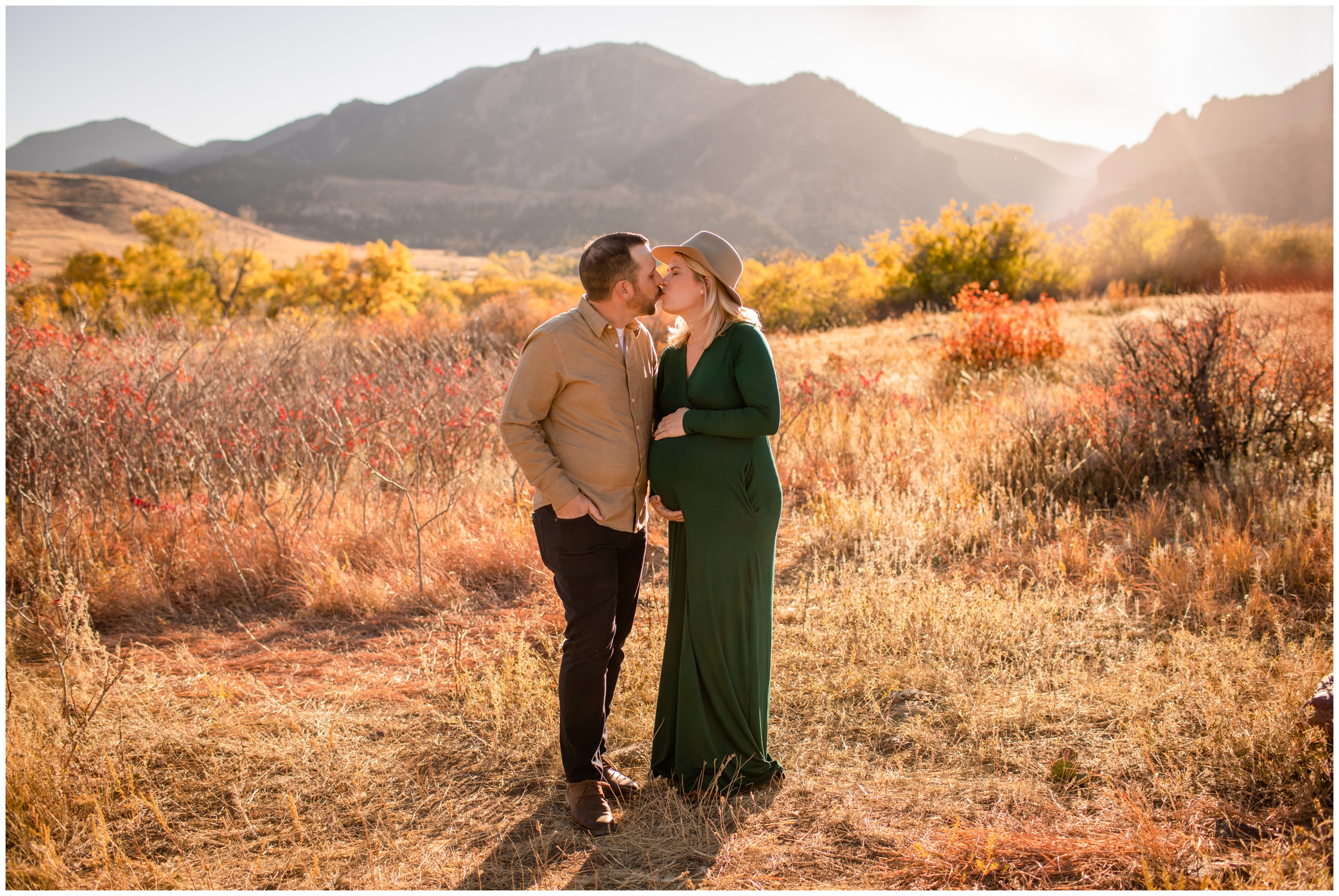 couple kissing with mountains in background during Boulder maternity portraits at South Mesa