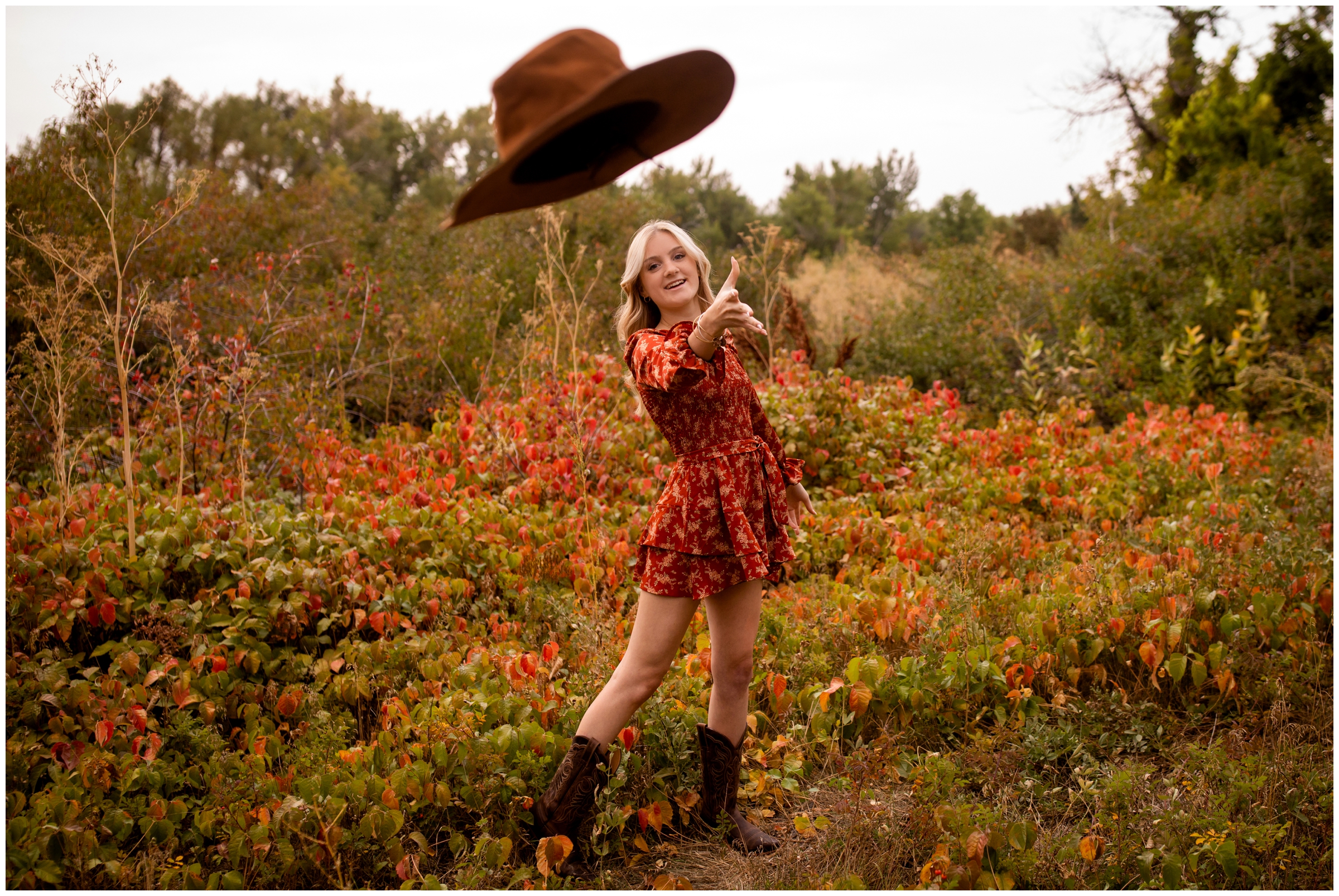 teen girl throwing her hat during unique senior portraits in Boulder Colorado 