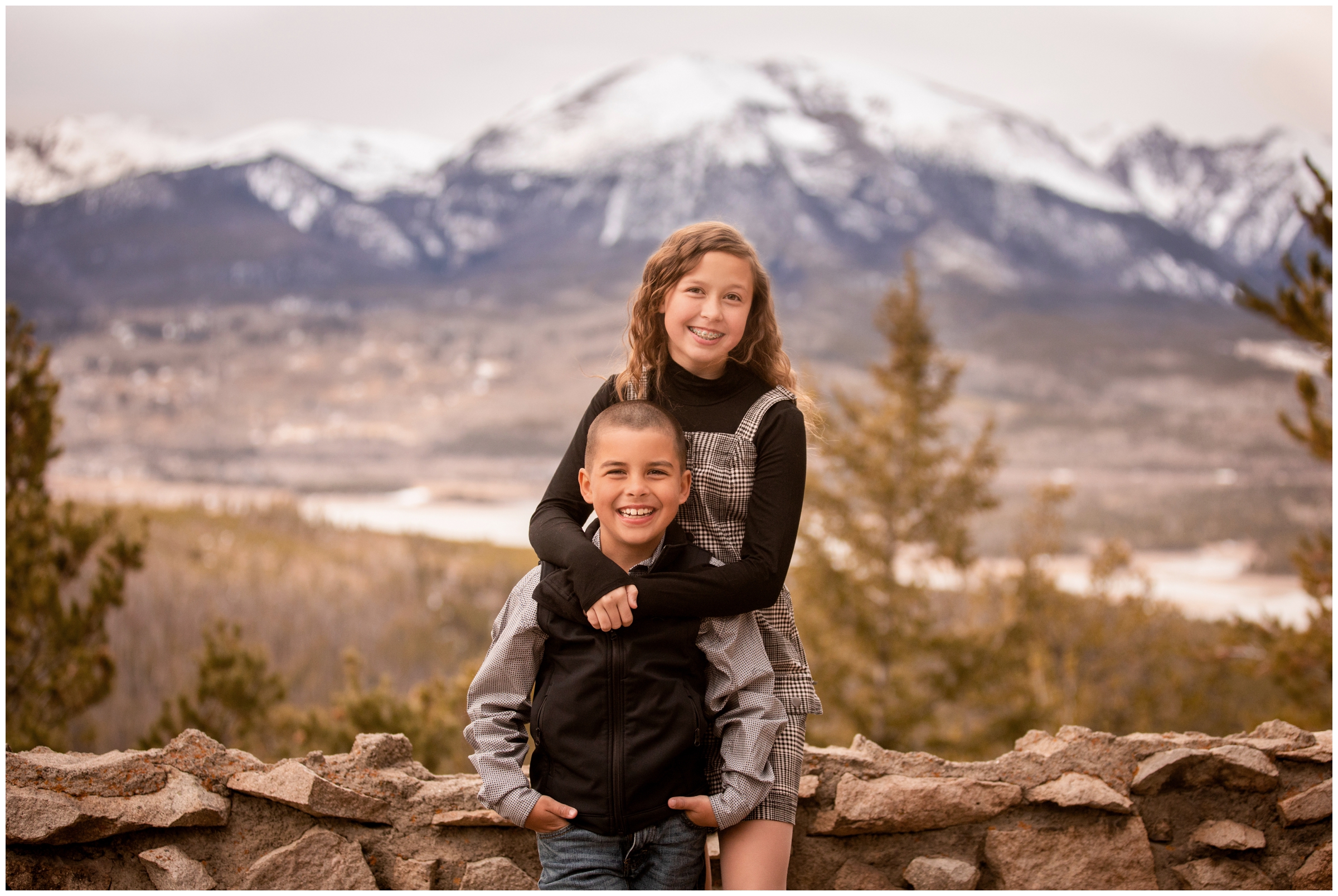 siblings hugging with mountains in background during family photo session at Sapphire Point Colorado 