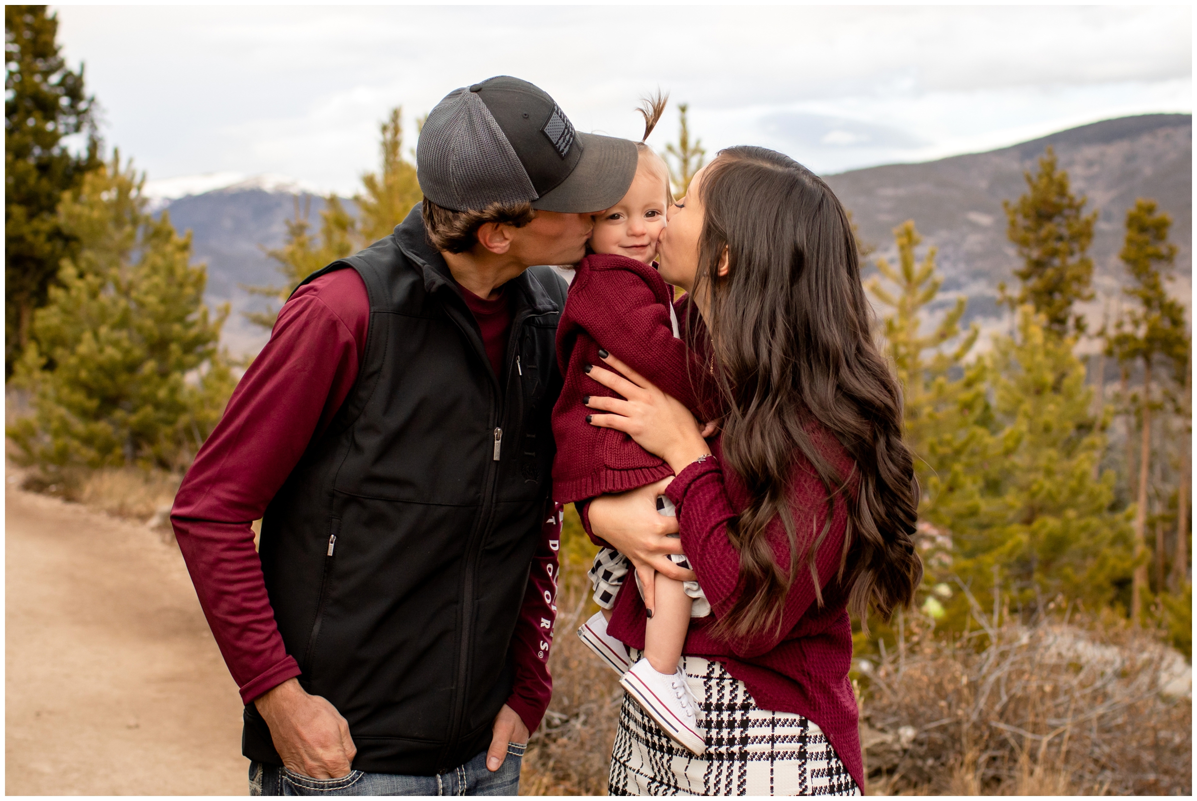 parents kissing daughter during family photos in Breckenridge Colorado mountains 