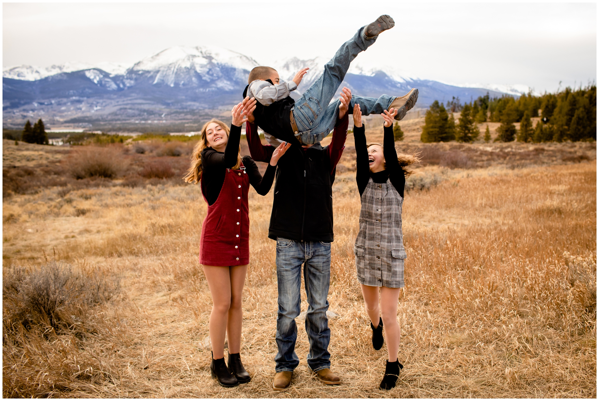 kids throwing little brother in air during candid Colorado family pictures in Breckenridge 