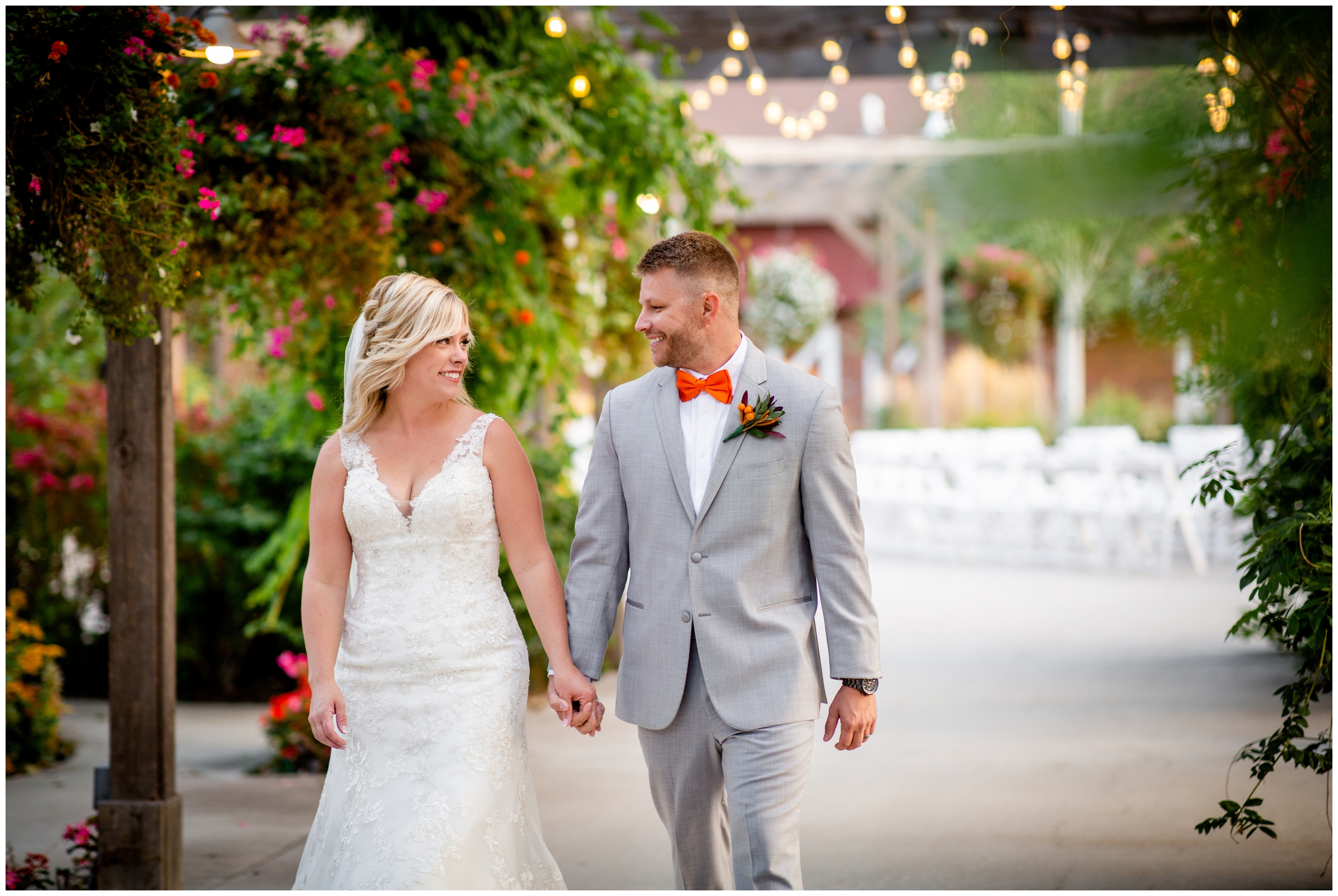 couple walking under market lights during Brookside Gardens Colorado wedding pictures 