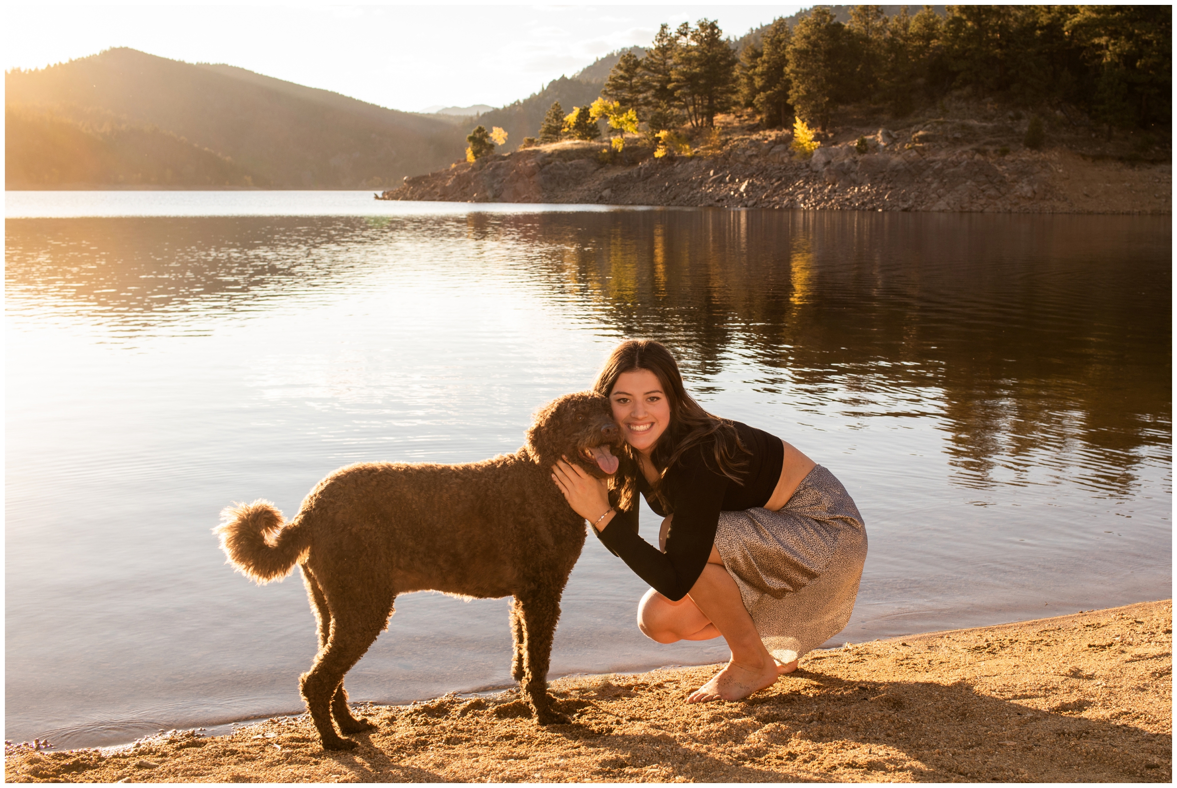 high school senior posing with her dog during Colorado mountain lake senior portraits at Gross reservoir