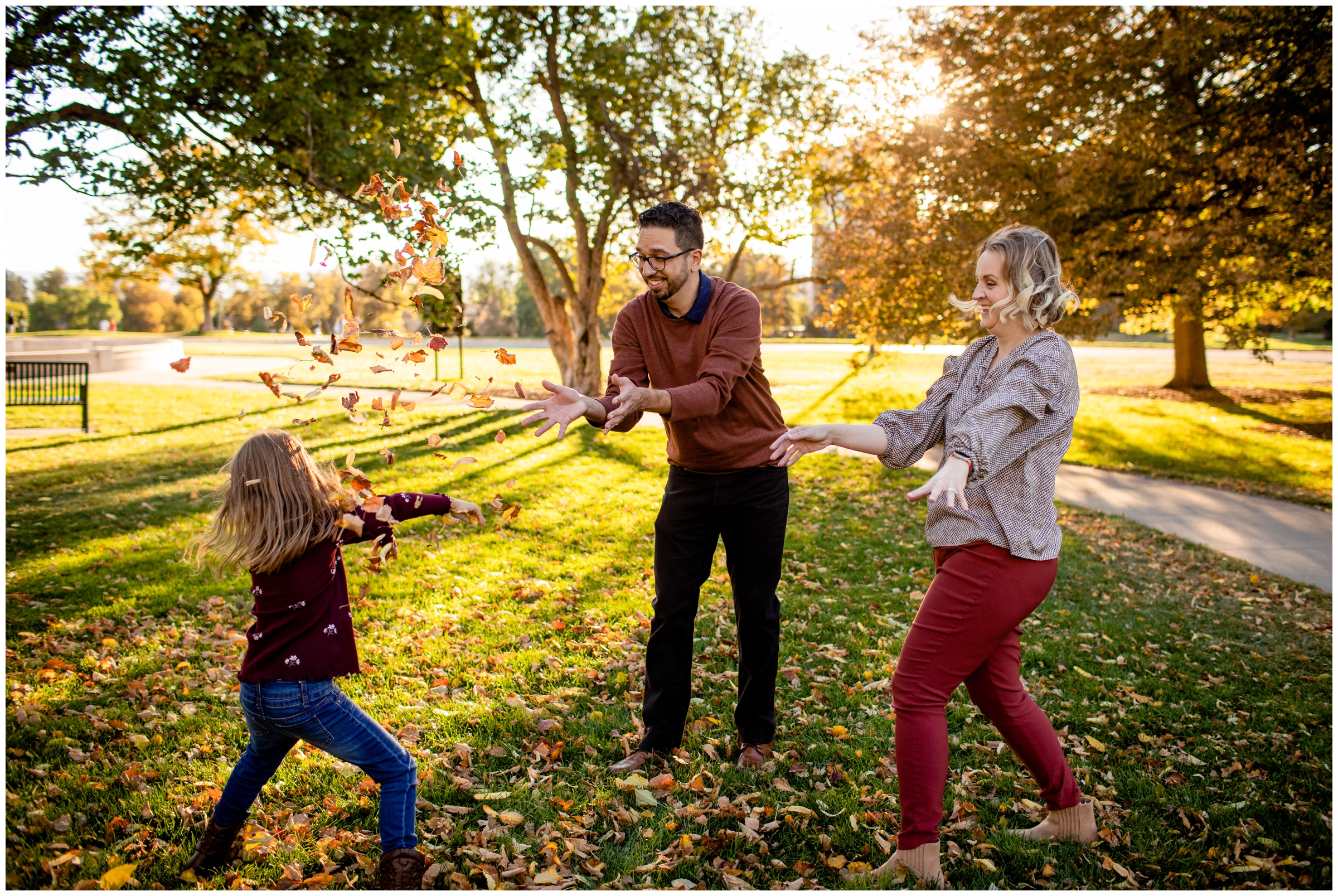 family throwing leaves at each other during Cheesman Park Denver photography session 