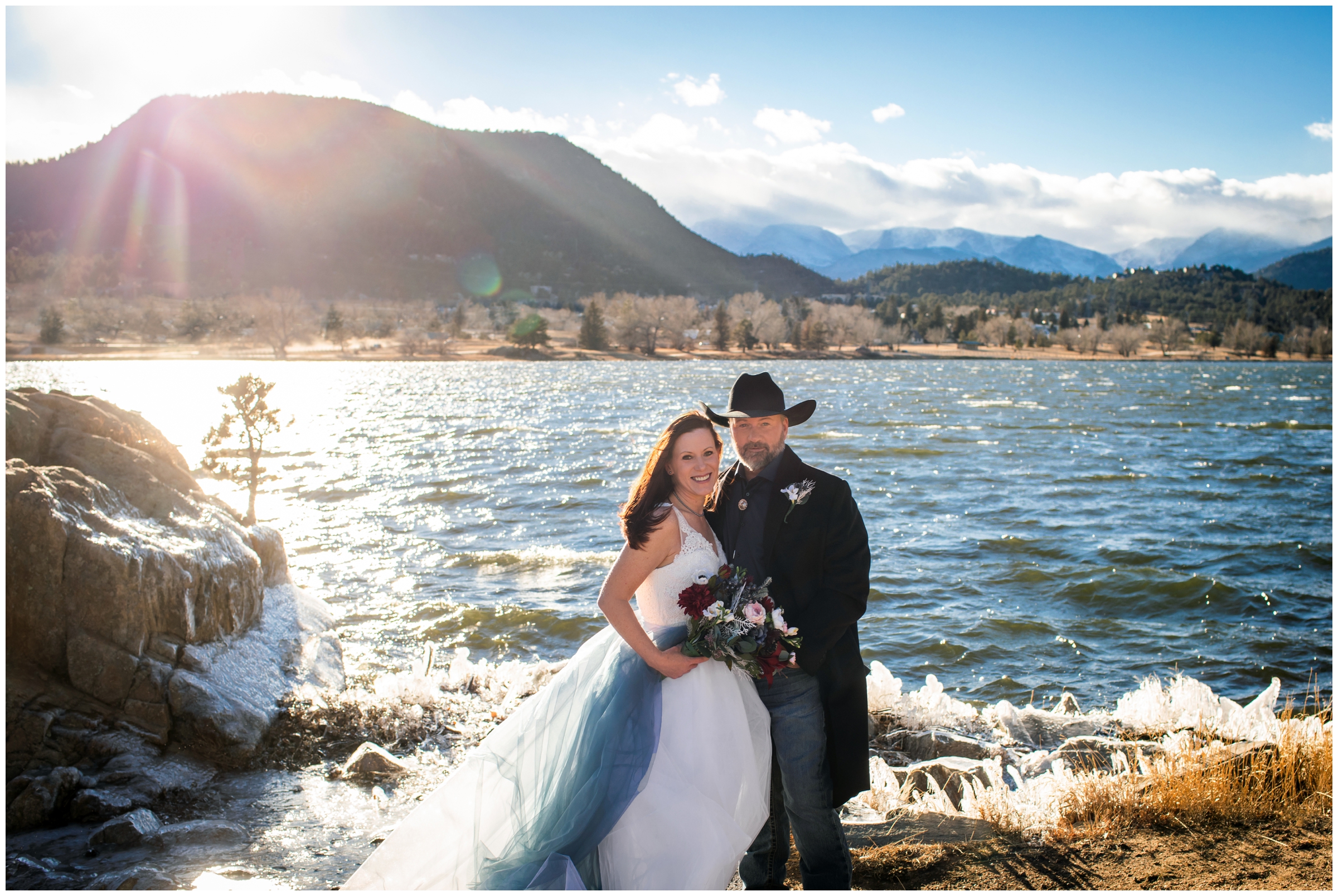 couple posing in front of mountain lake during winter elopement wedding pictures at the Estes Park Resort 