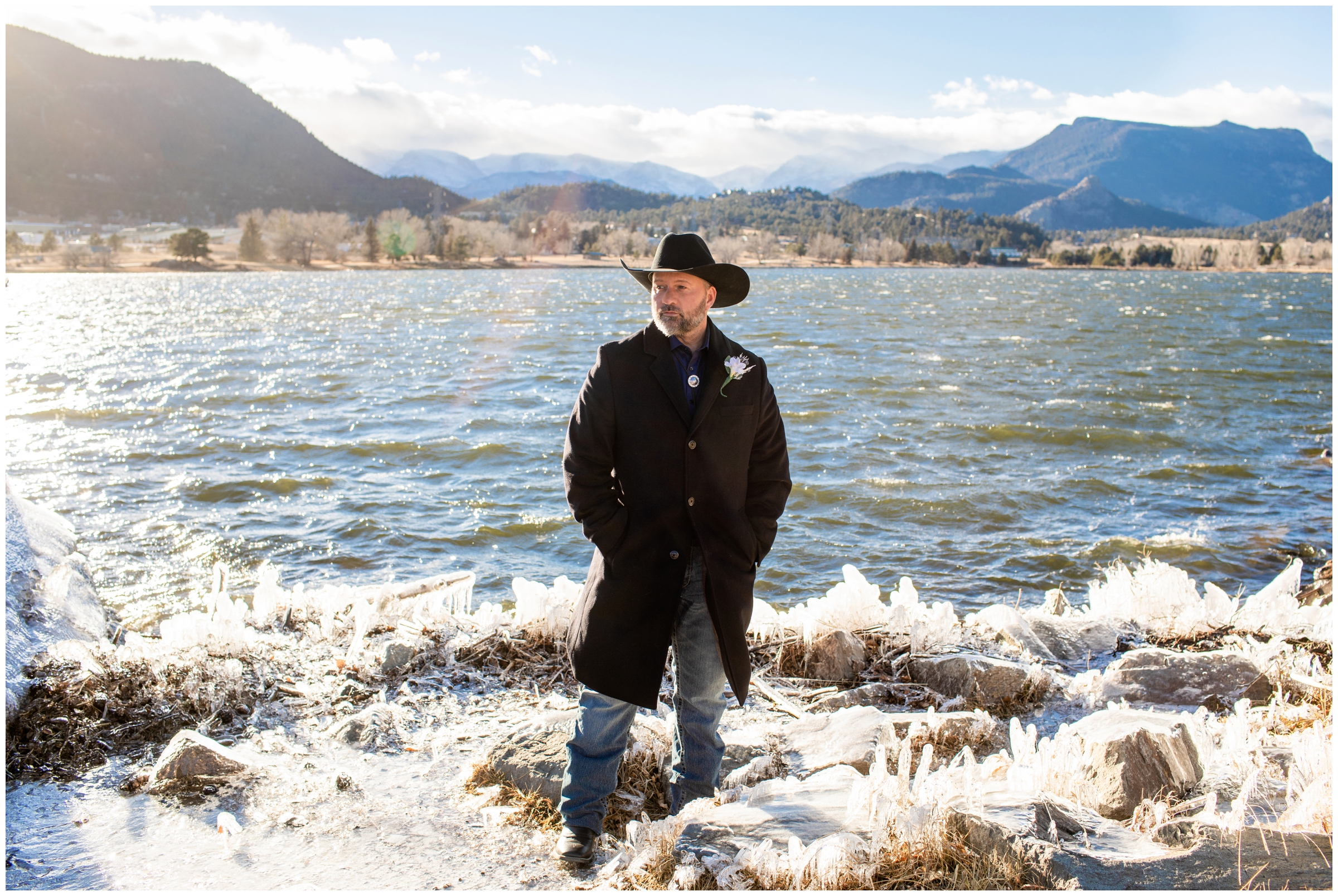 groom standing on frozen lake during Estes Park Resort Colorado winter wedding pictures 