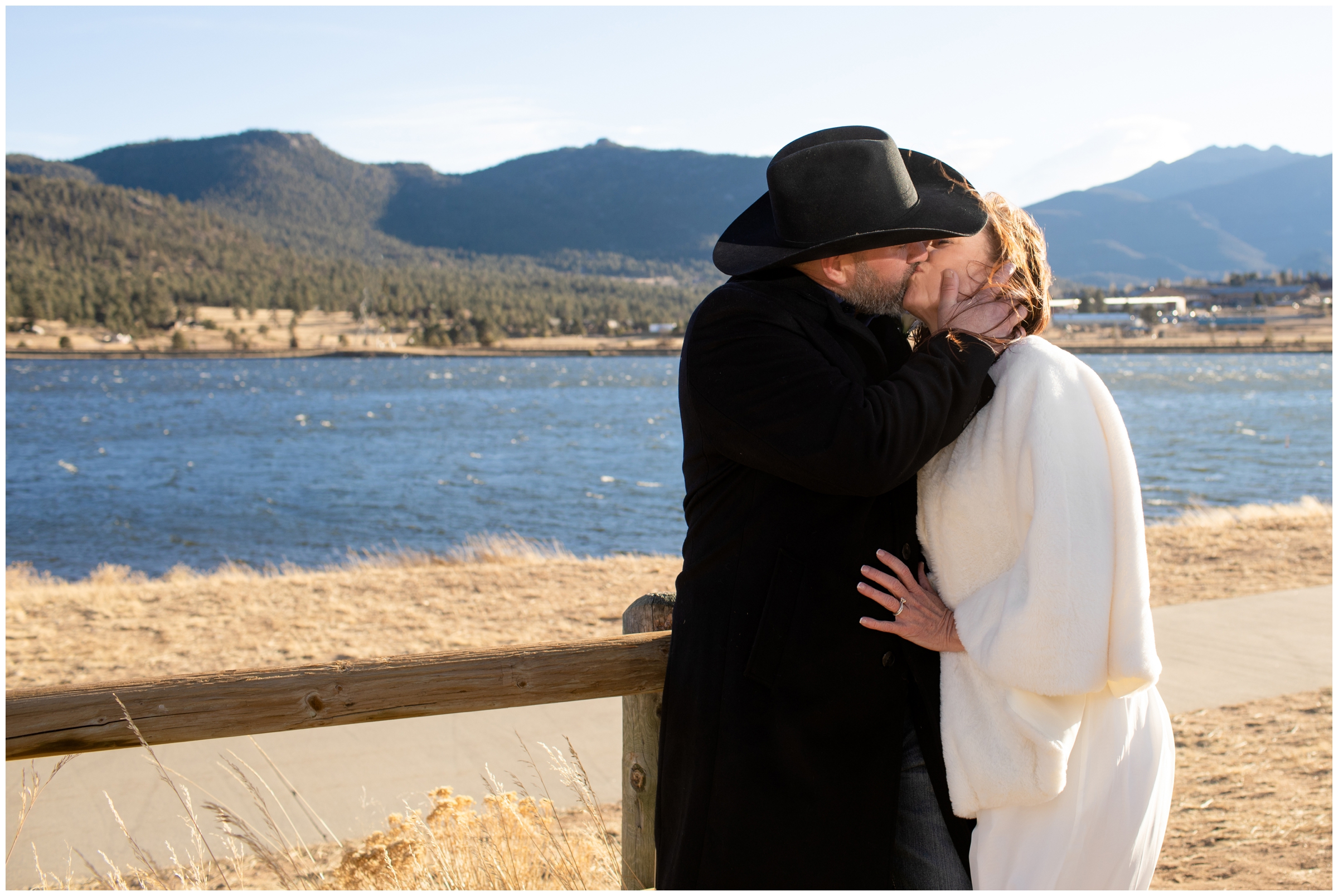 couple kissing with mountain lake in background during Estes Park Resort winter elopement wedding