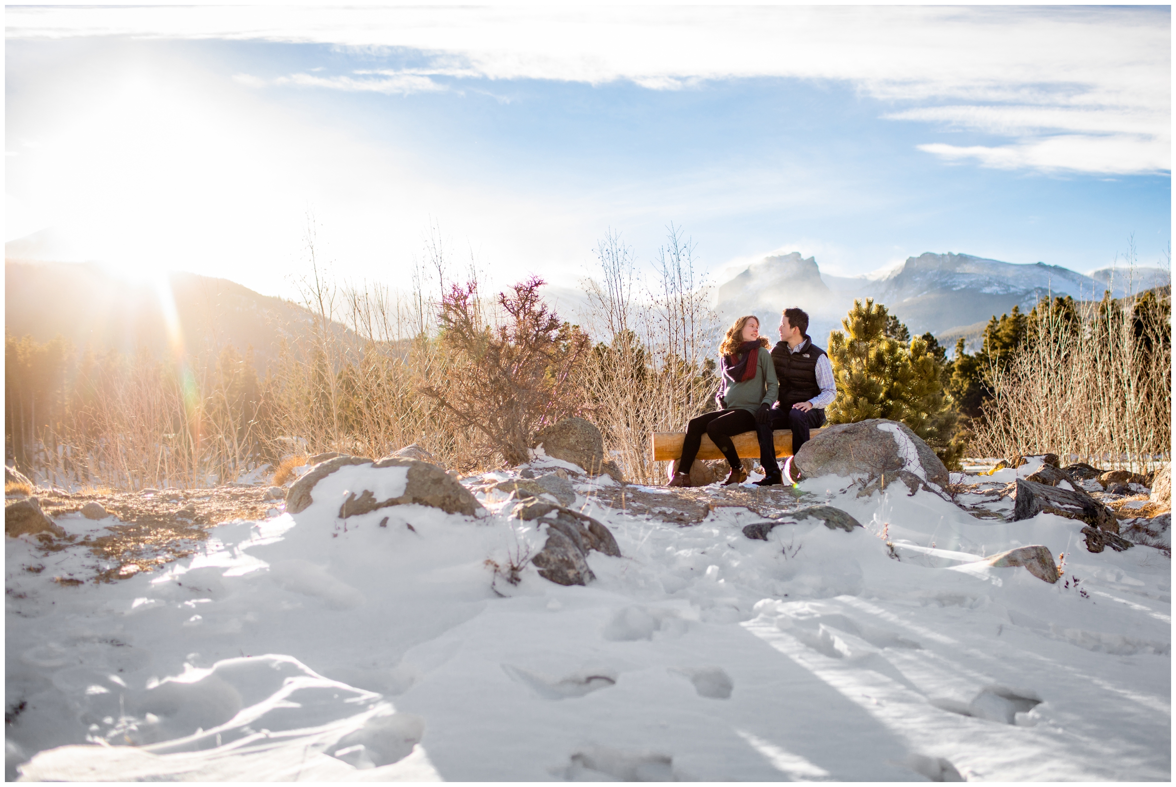 couple sitting on a bench with mountains in background during Estes Park maternity photography session in RMNP