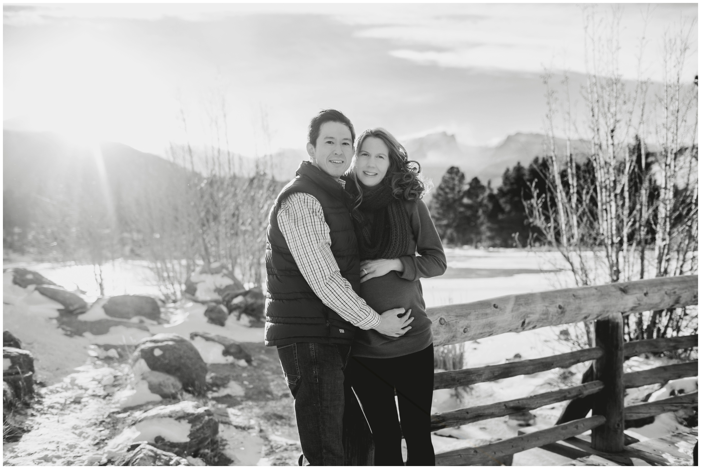 couple leaning against bridge during RMNP mountain pregnancy photo shoot at Sprague Lake