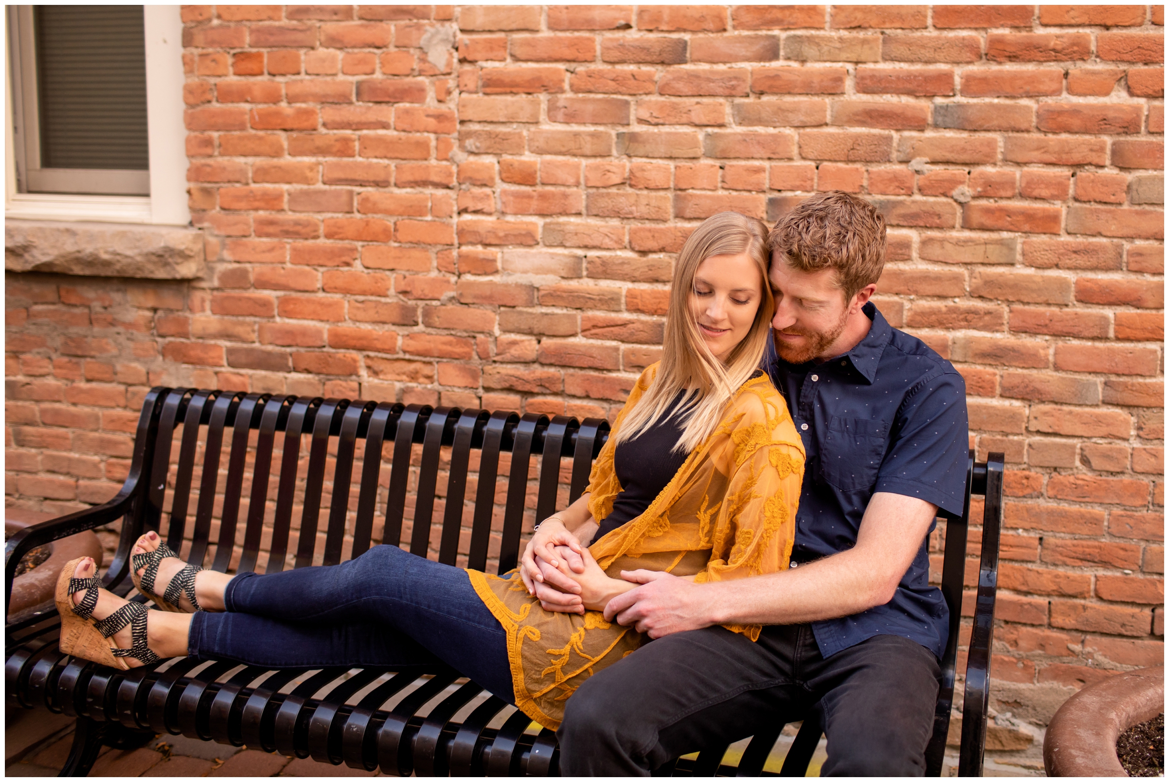 fiancées cuddling on bench during Colorado couples photo shoot