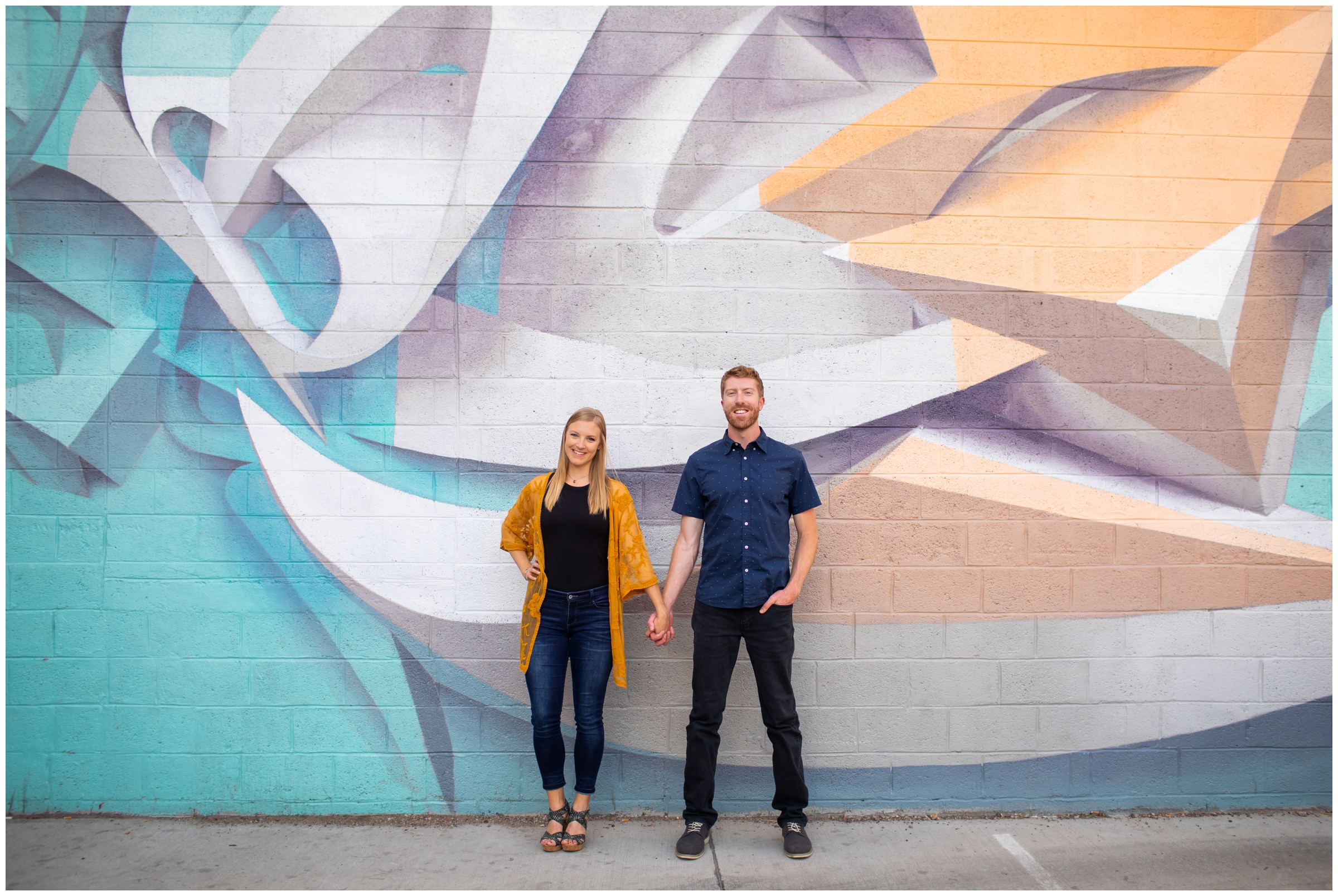 couple posing in front of colorful wall mural during urban engagement pictures in old town Fort Collins 