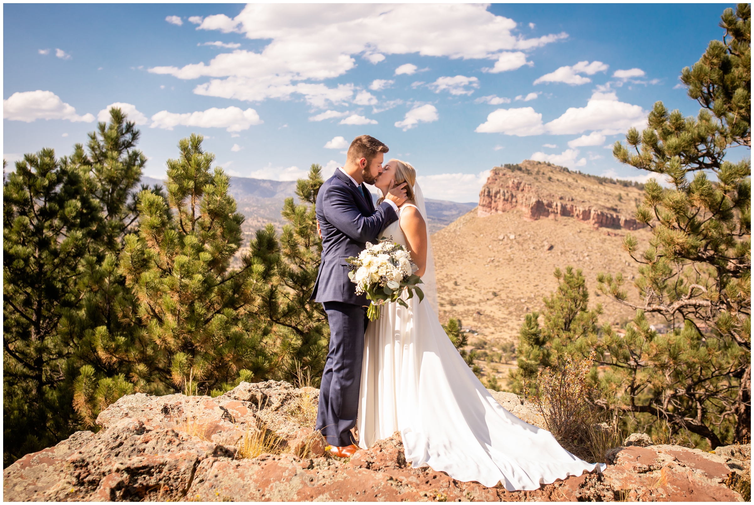 couple kissing with mountains and rock formations in background during Lionscrest Manor Colorado wedding portraits