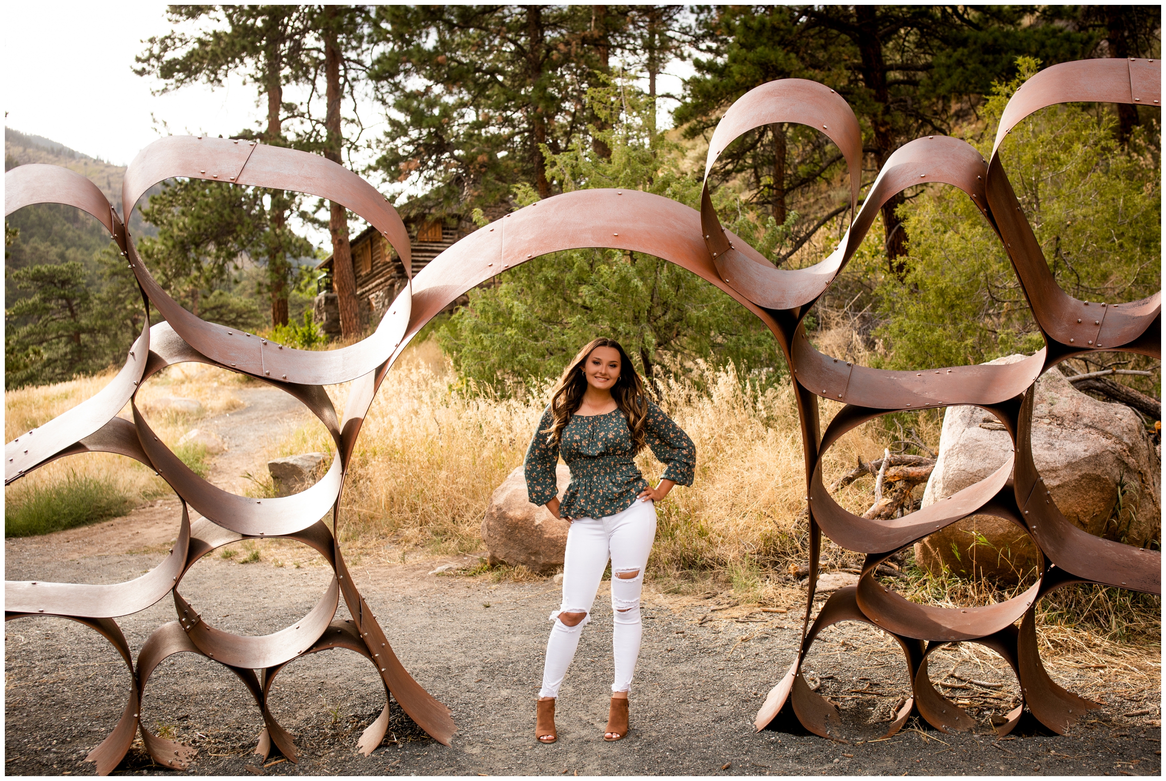 teen girl posing under metal art sculpture during Loveland Colorado senior photos by Plum Pretty Photography 
