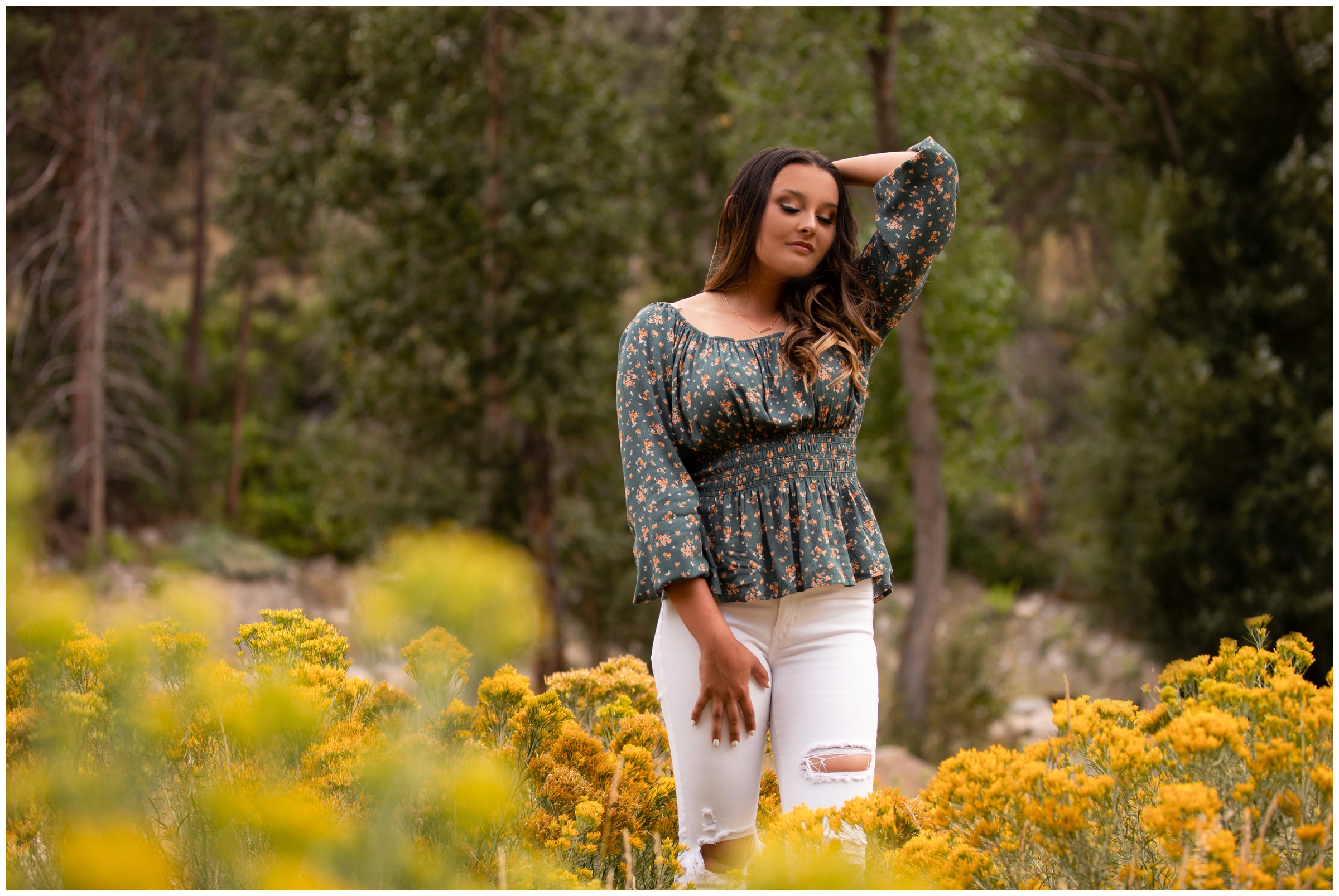 teen standing in flower field during Colorado mountain senior pictures