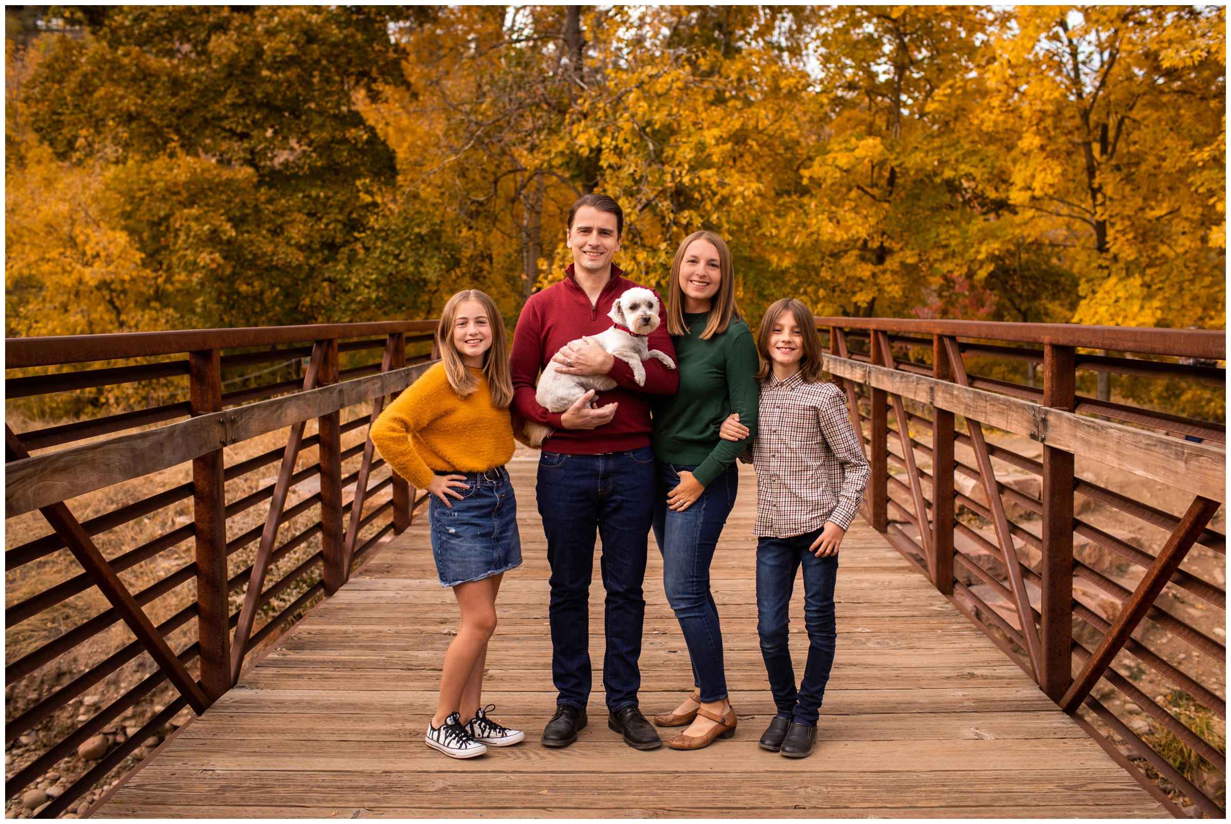 family posing on a bridge with their dog during fall family pictures in Lyons Colorado