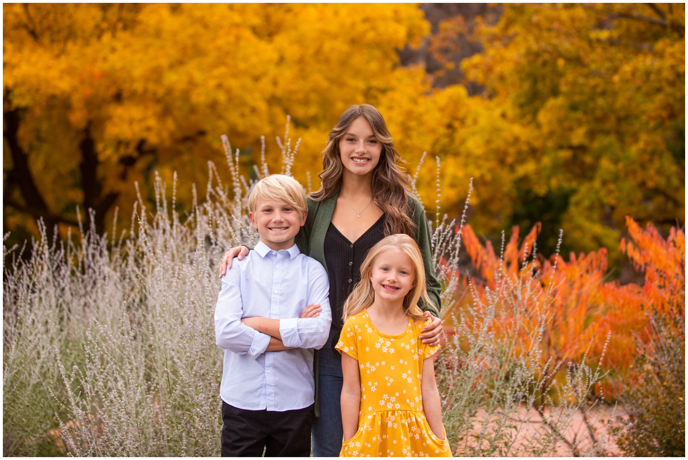 three kids posing with colorful fall foliage in background during Lyons Colorado family pictures by Plum Pretty Photography