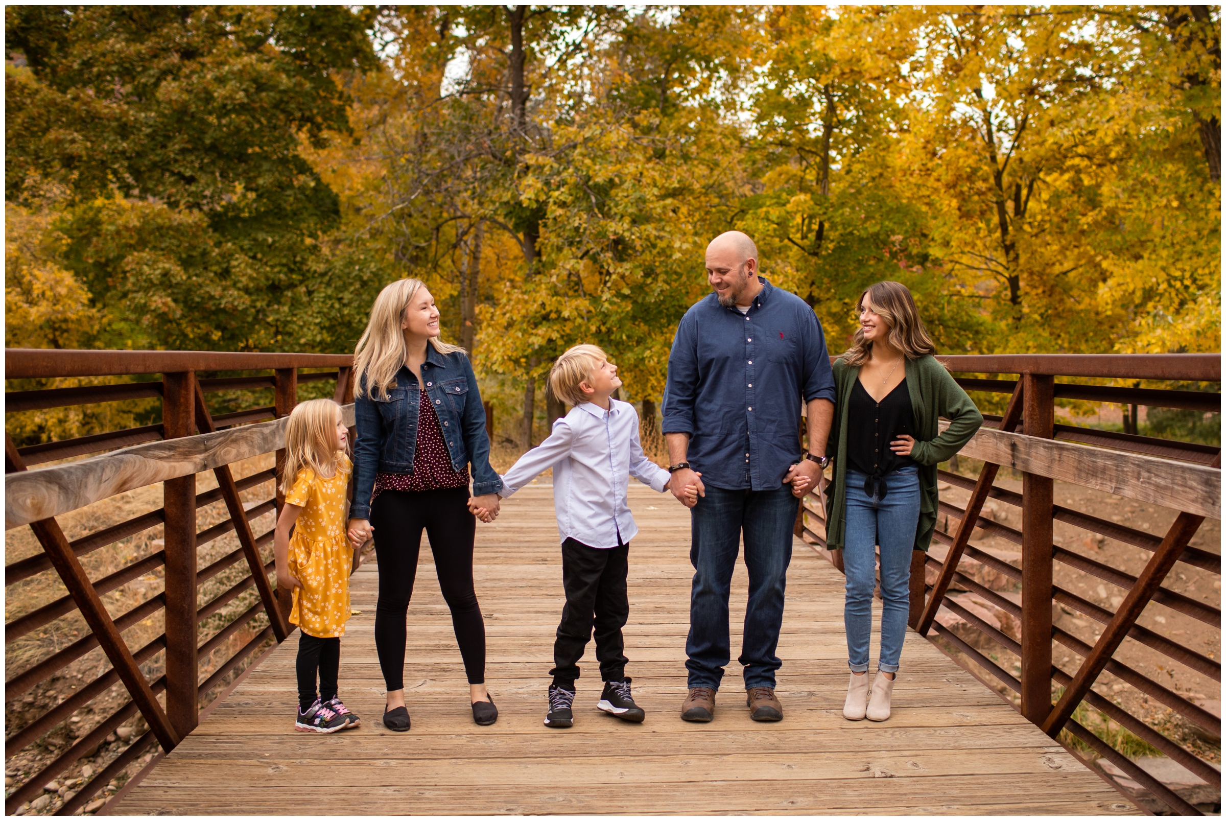 family walking on a bridge during candid photos in Lyons Colorado