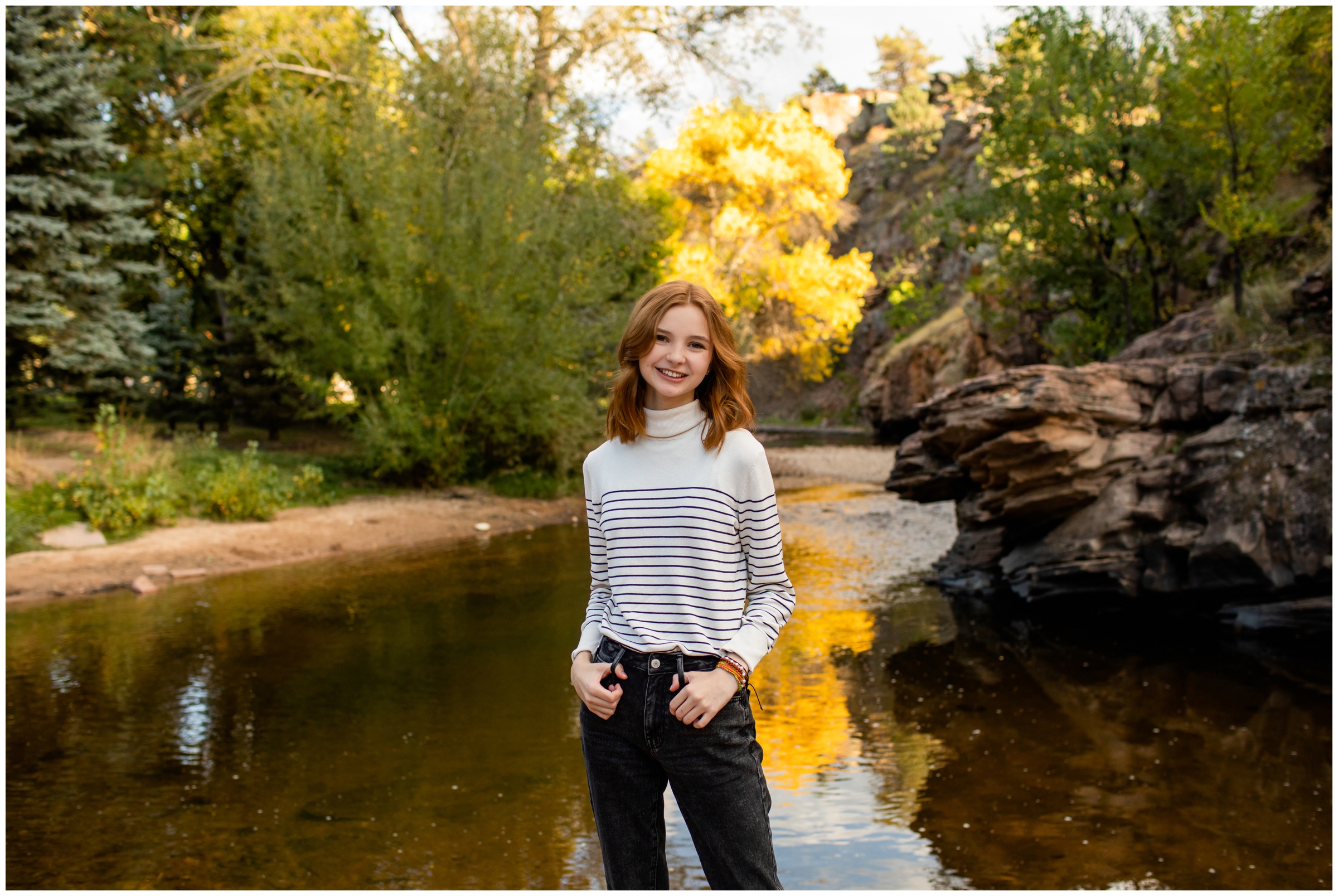 teen girl posing next to river during high school graduation photography session in Colorado 