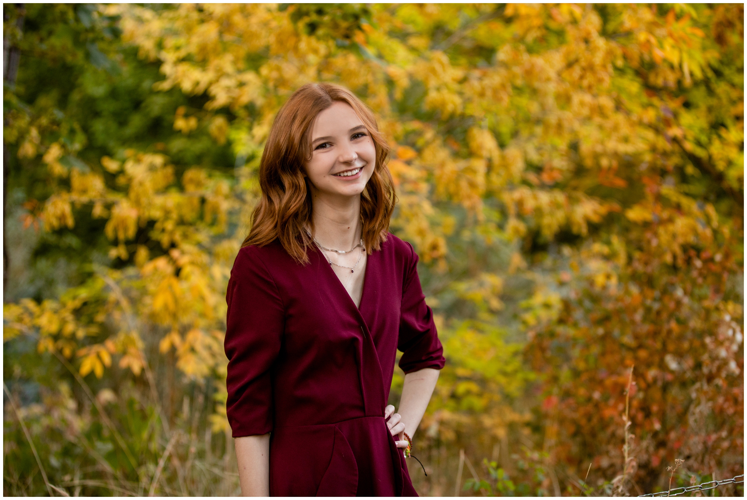 teen posing in front of colorful fall foliage during Colorado mountain senior portraits 
