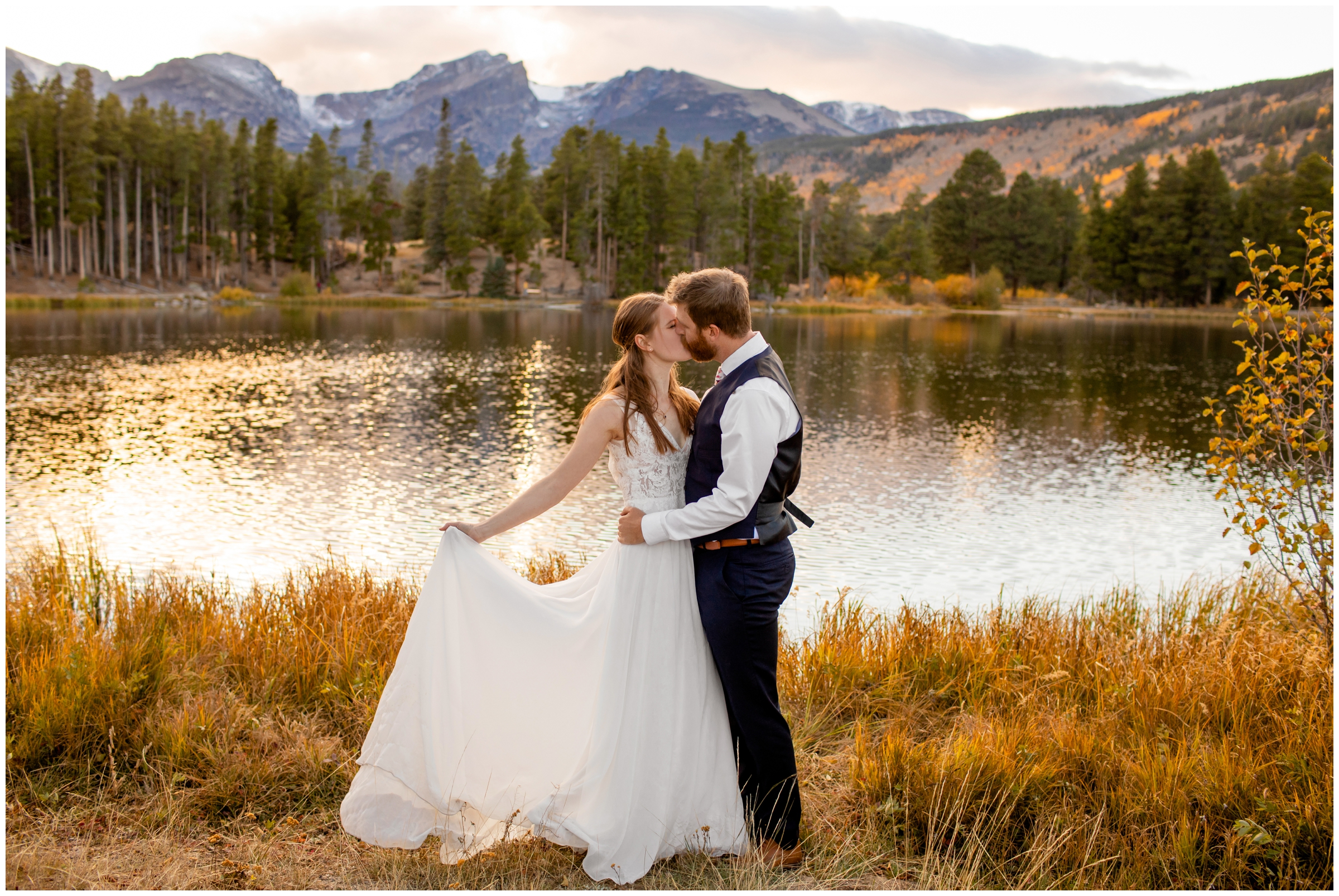 couple kissing in front of a mountain lake during RMNP wedding photos at Sprague Lake in Estes Park Colorado