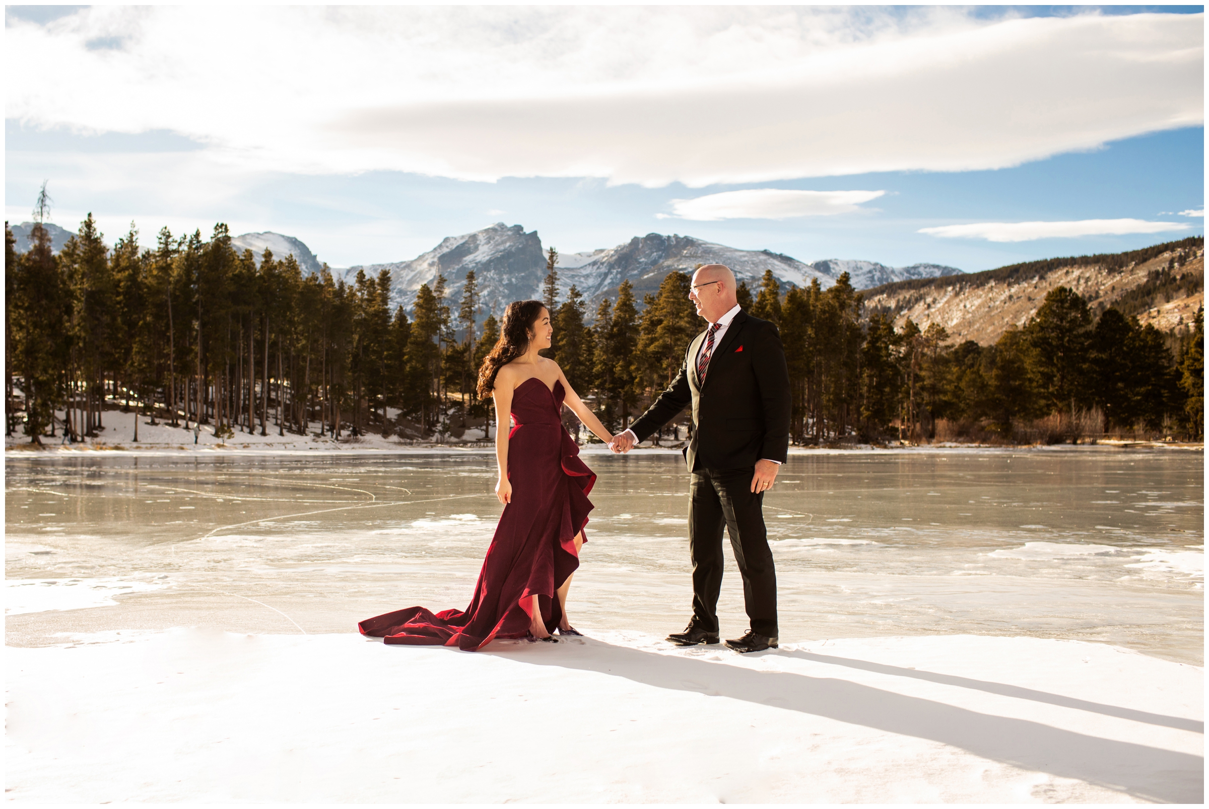 couple holding hands on frozen mountain lake in Estes Park Colorado