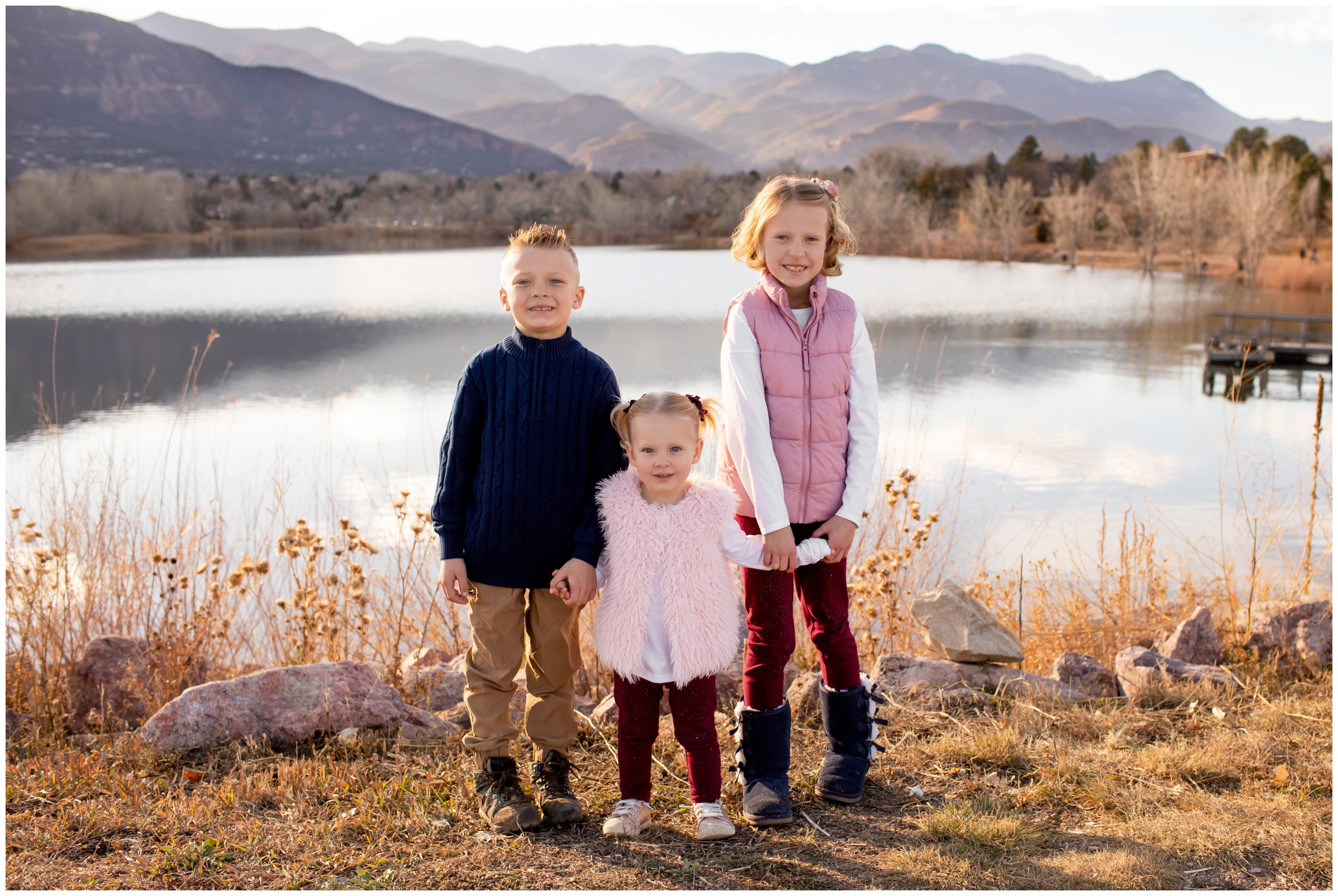 siblings posing in front of lake during Colorado Springs fall family photos