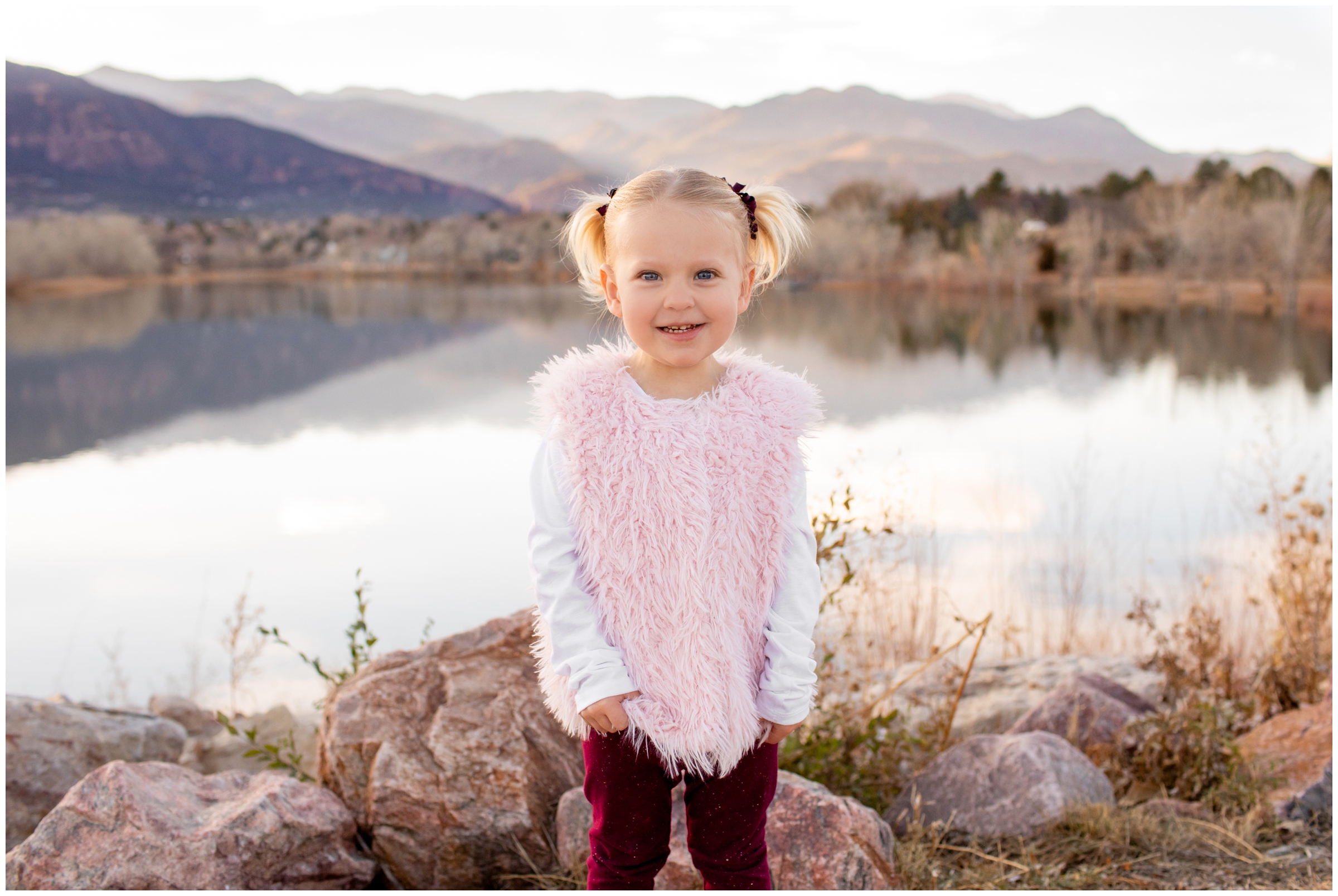 little girl posing next to mountain lake during Colorado springs family photography session 