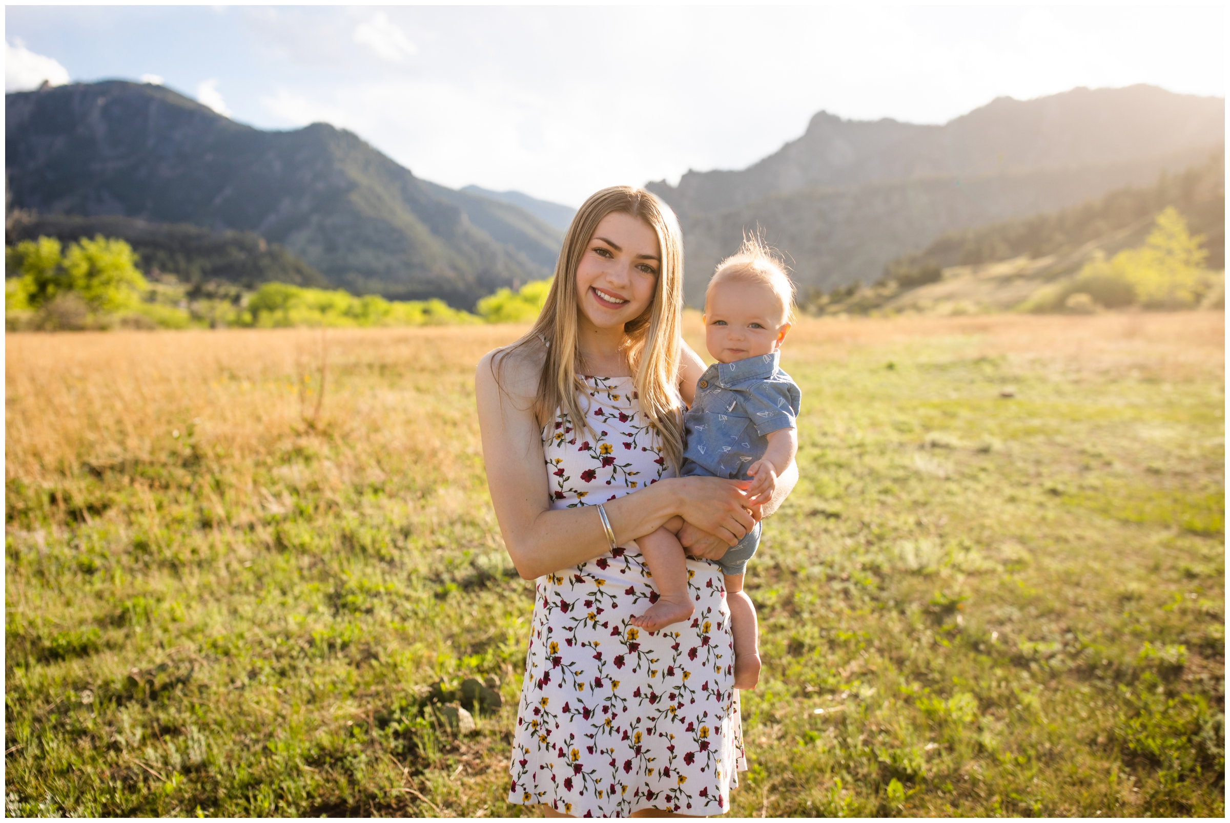 mom holding baby son with mountains in background during spring family photos in Boulder Colorado 