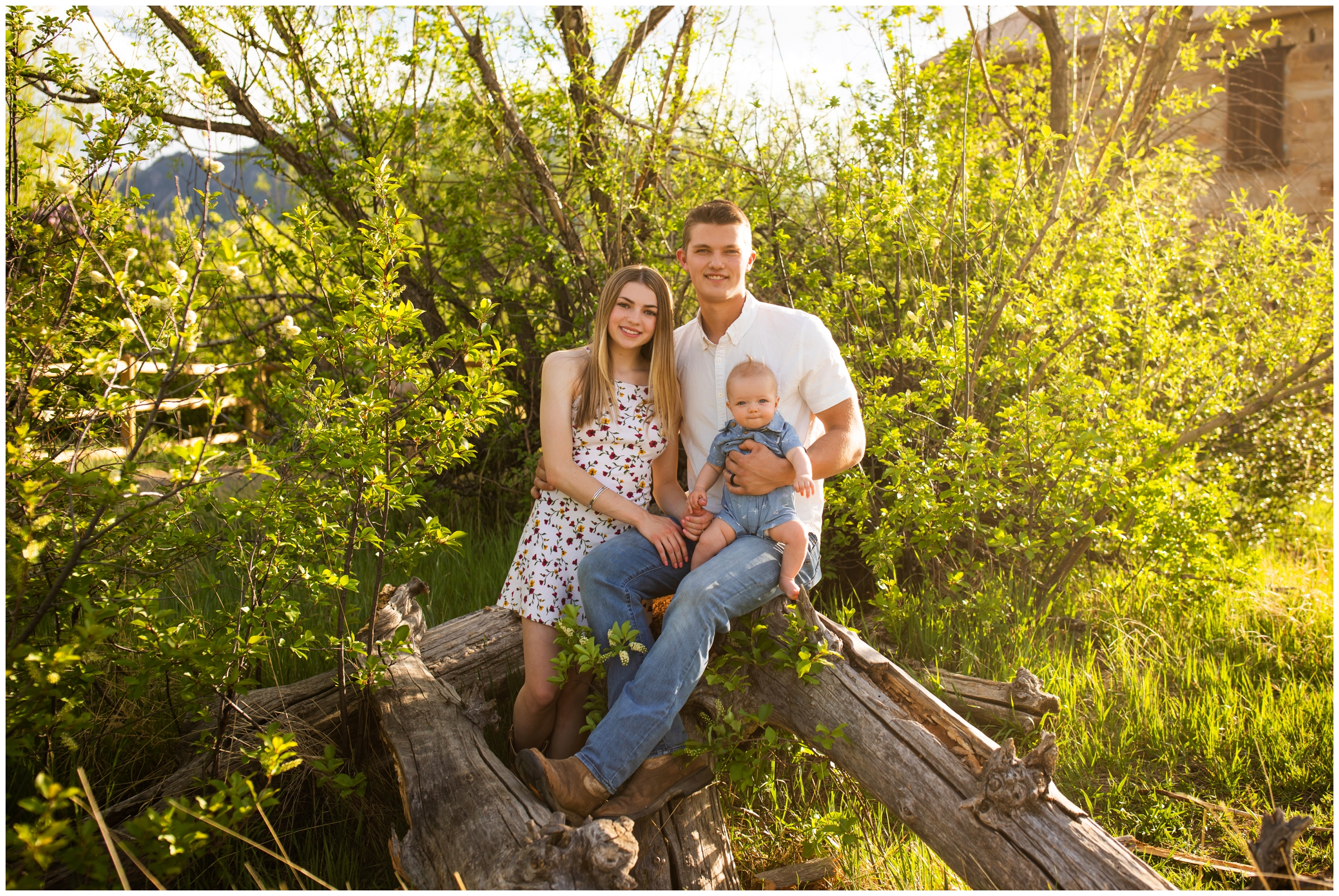 family of three sitting on a downed tree at South Mesa Trail during Boulder senior photos 