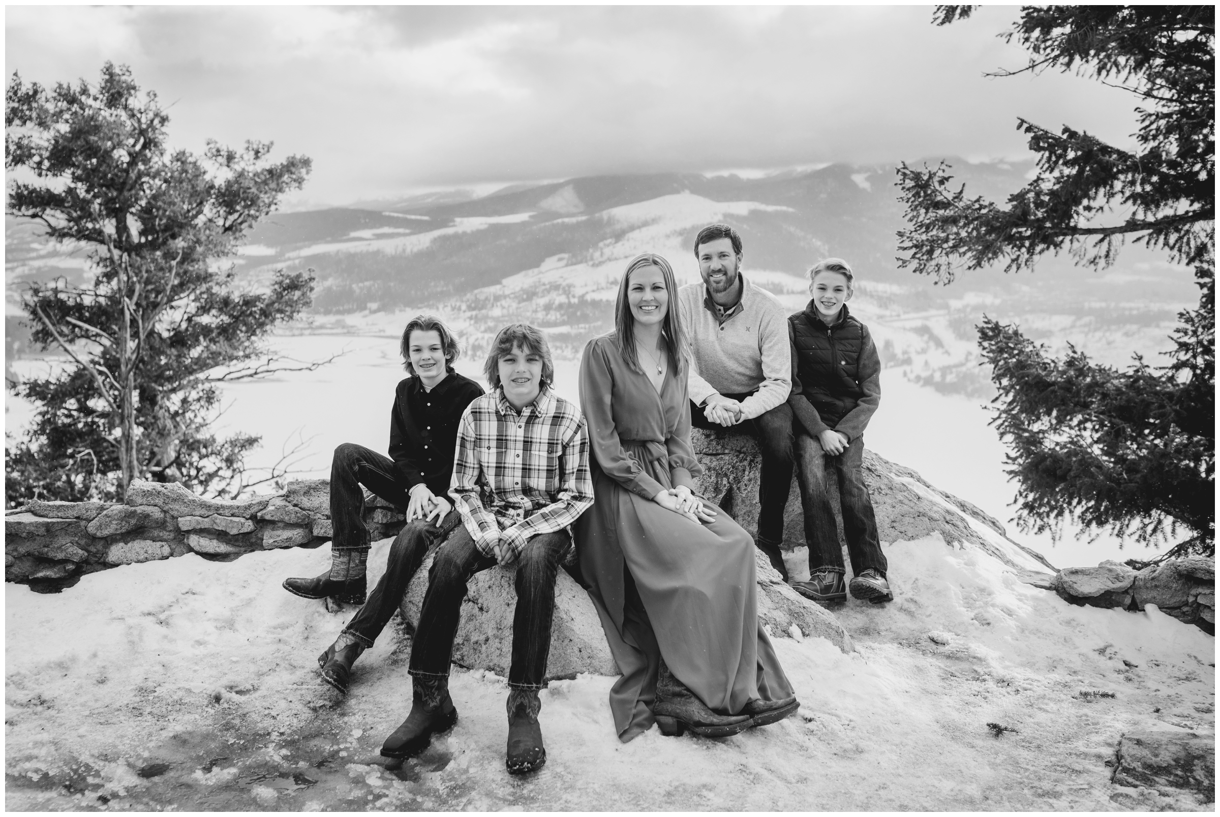 family sitting on rocks at Sapphire Point Overlook during Colorado winter family pictures