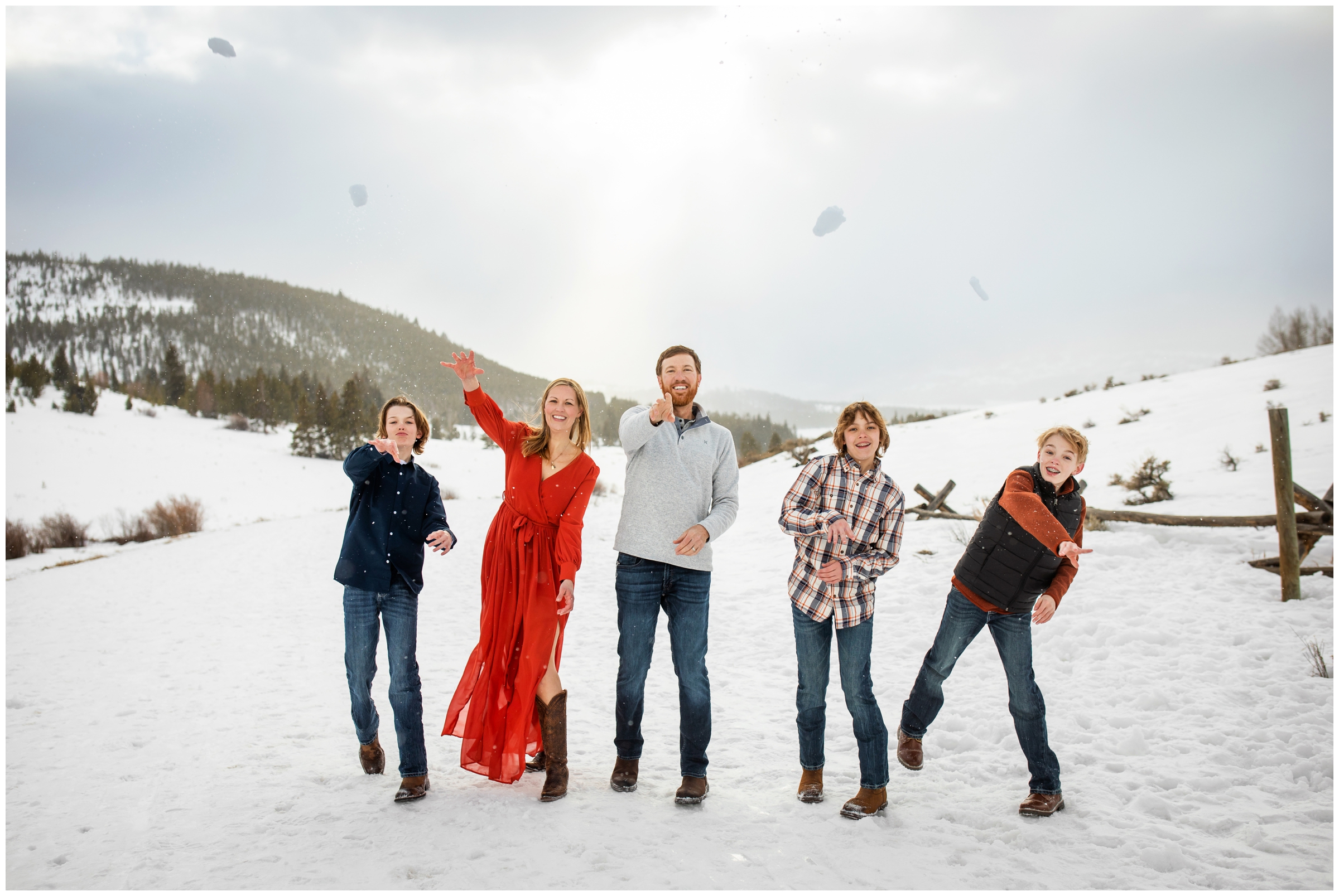 family throwing snowballs at the camera during Breckenridge Colorado winter family pictures at Windy Point