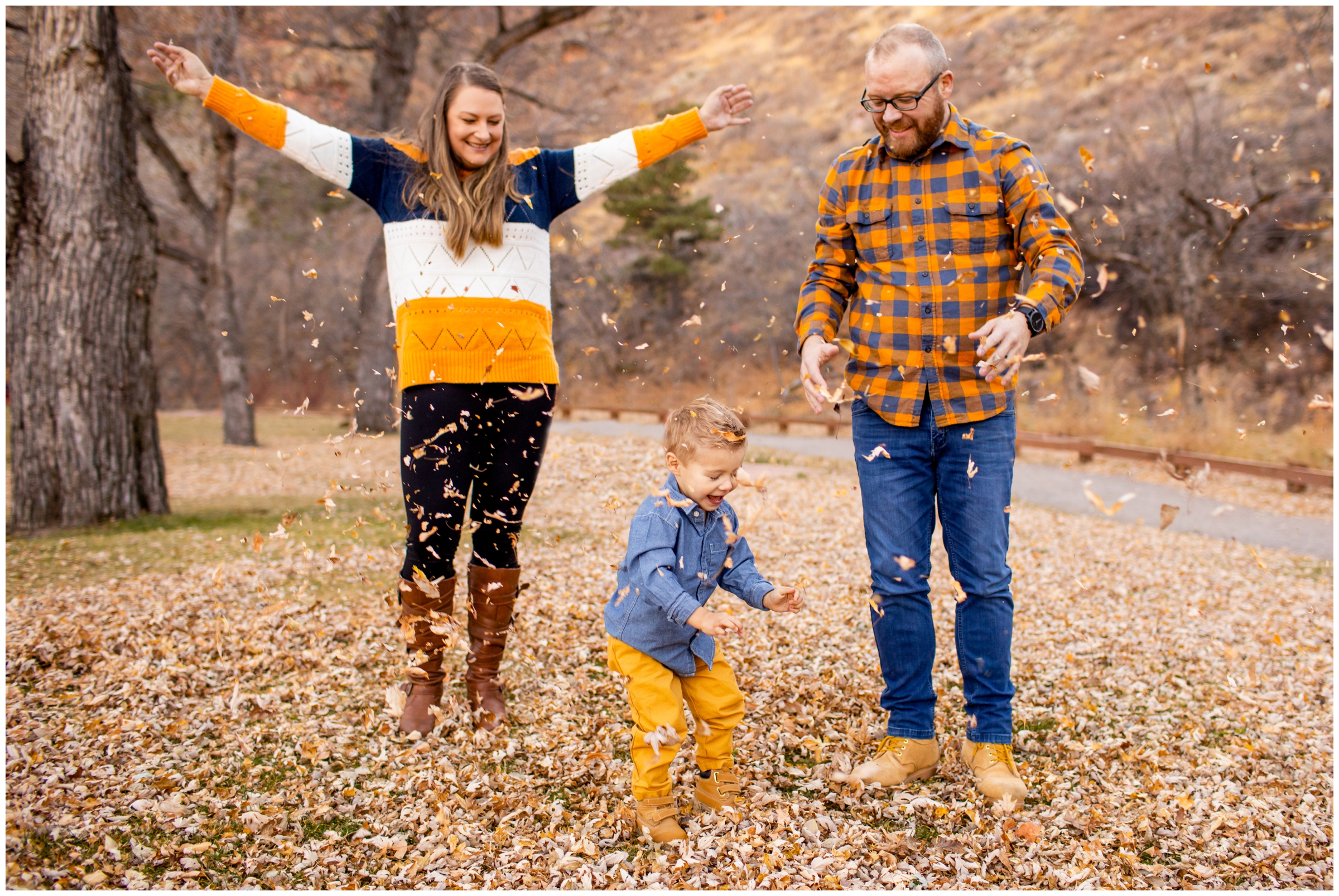 family throwing leaves during candid family pictures in the Colorado mountains