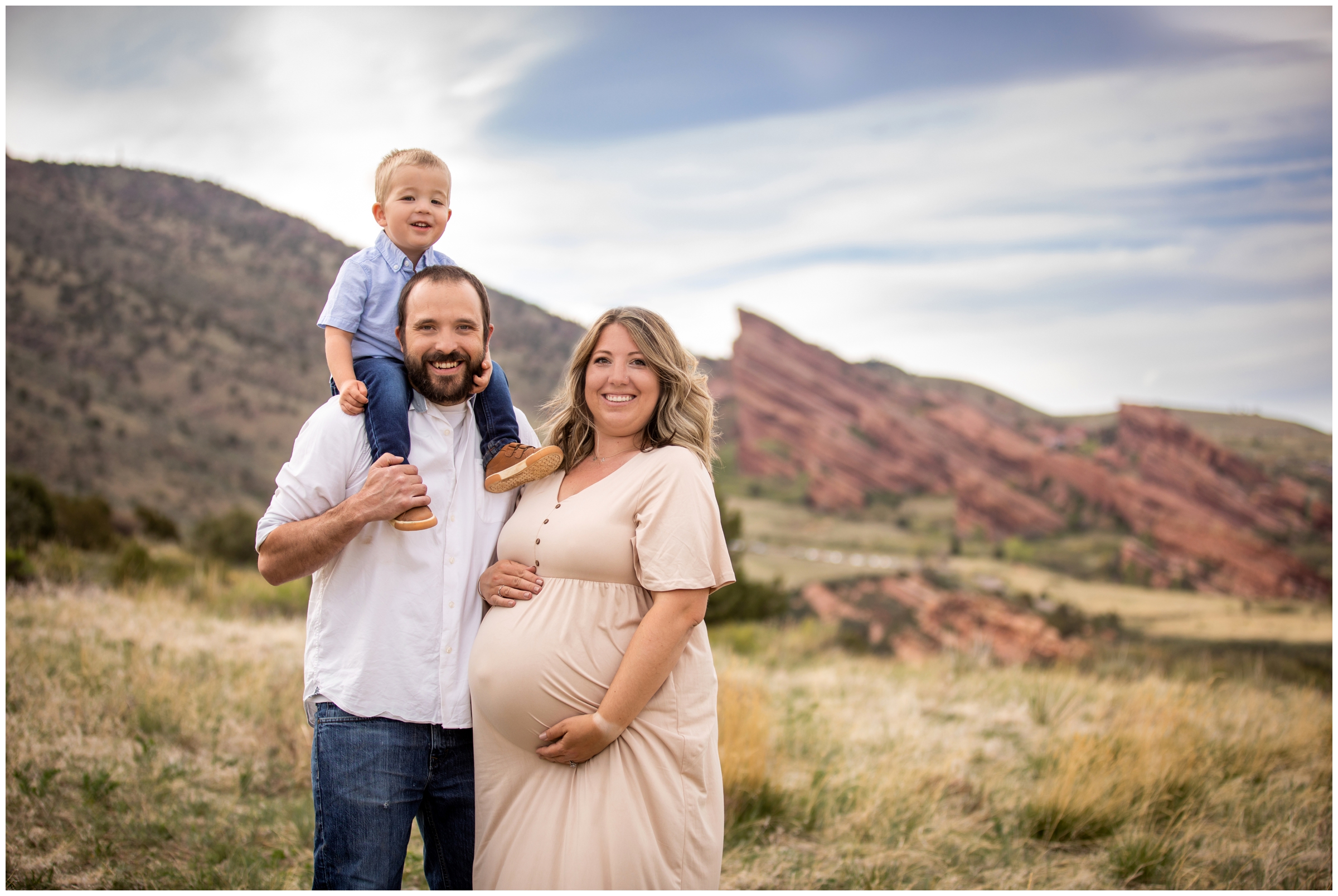 little boy on dad's shoulders with red rocks in background during Colorado family maternity photo shoot 