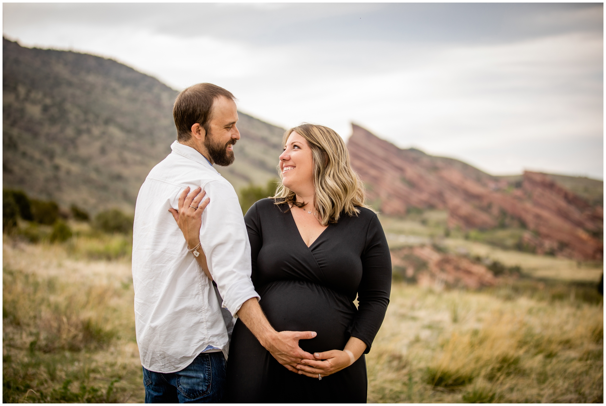 couple posing for CO maternity portraits with red rocks in the background 
