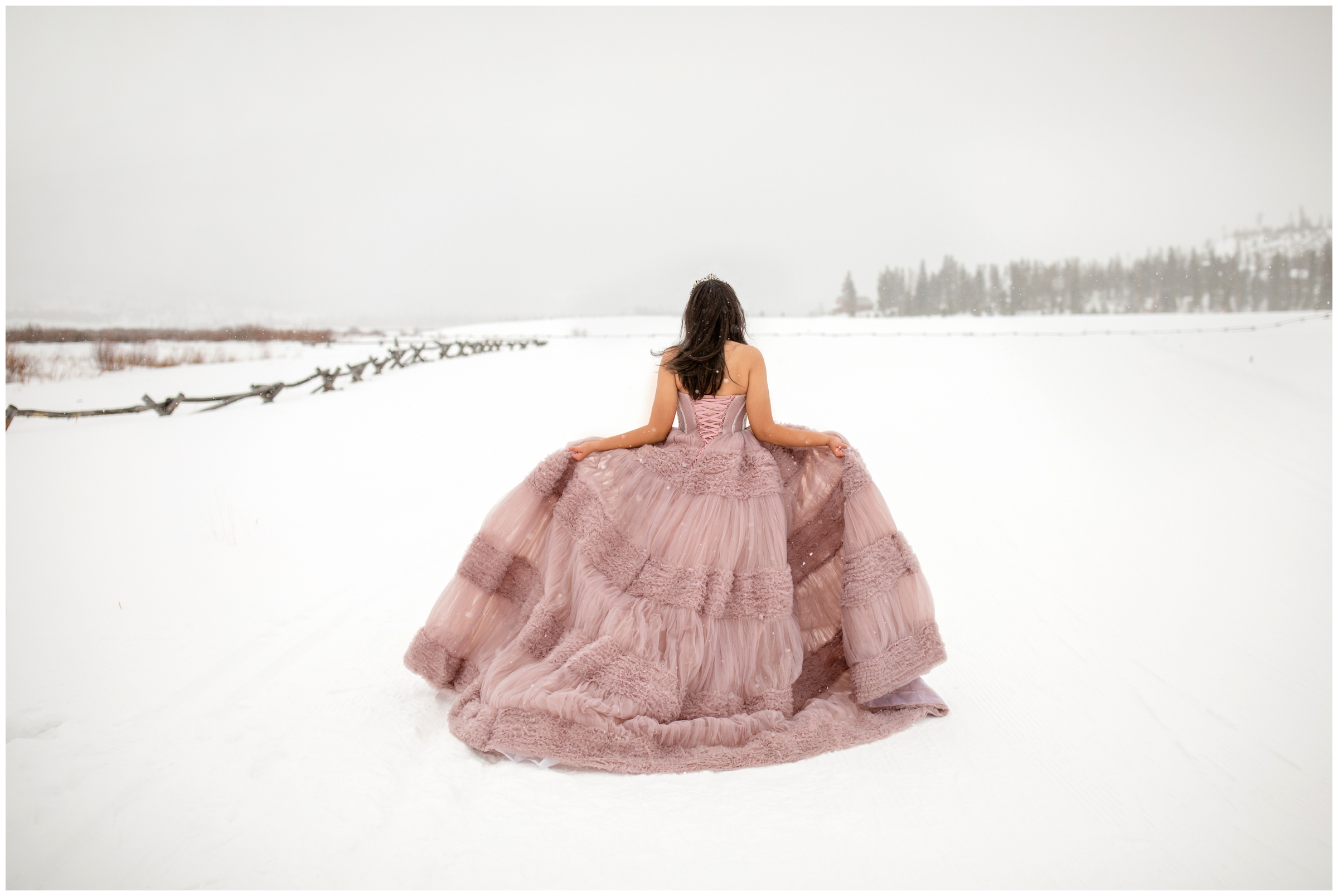 teen walking in pink ballgown during snowy Colorado quinceañera photoshoot in Winter Park 