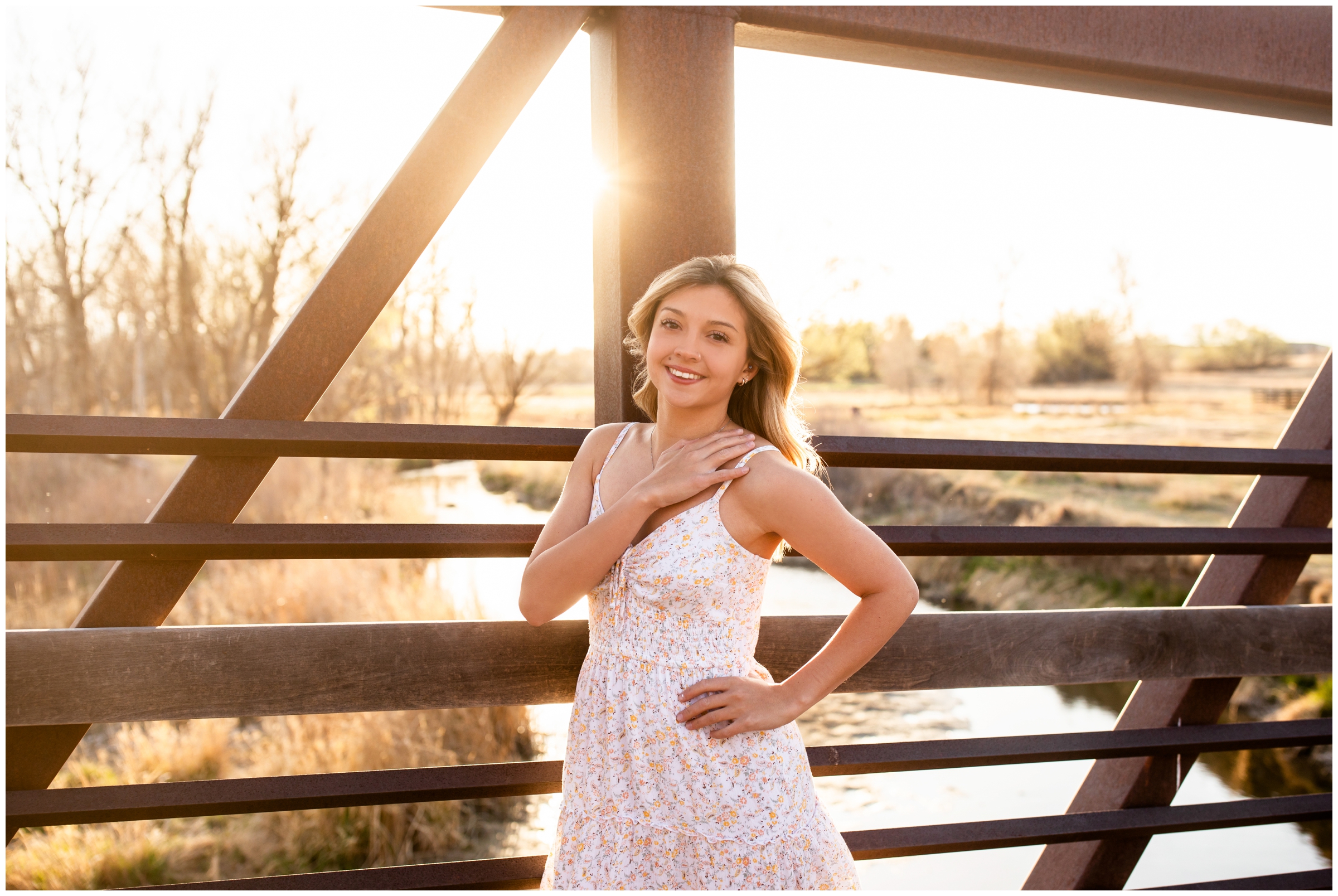 teen posing on a bridge at Sandstone Ranch in Longmont during high school graduation portraits 