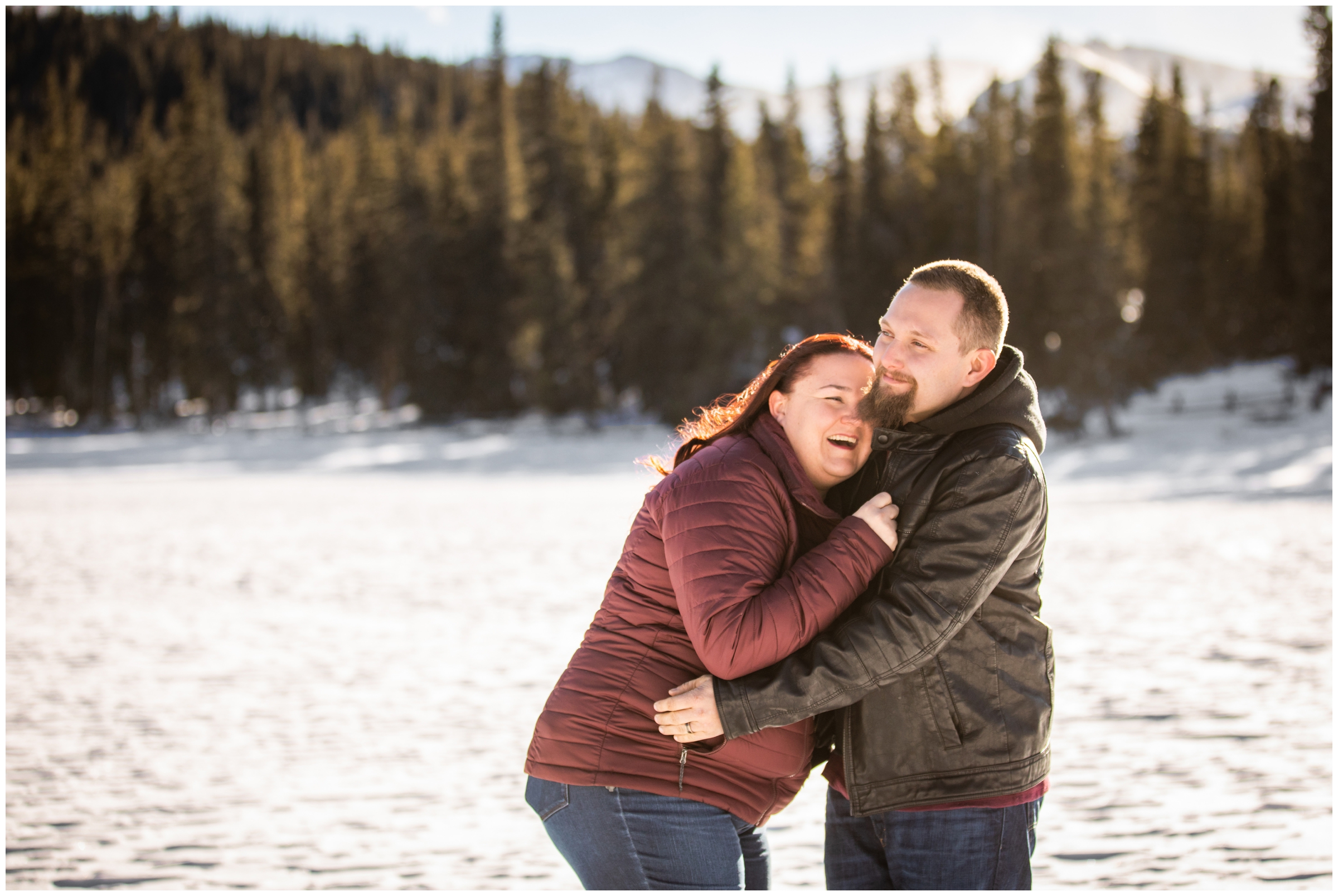 couple laughing in the snow during Colorado winter engagement portraits at Echo Lake Park by mountain wedding photographer Plum Pretty Photography
