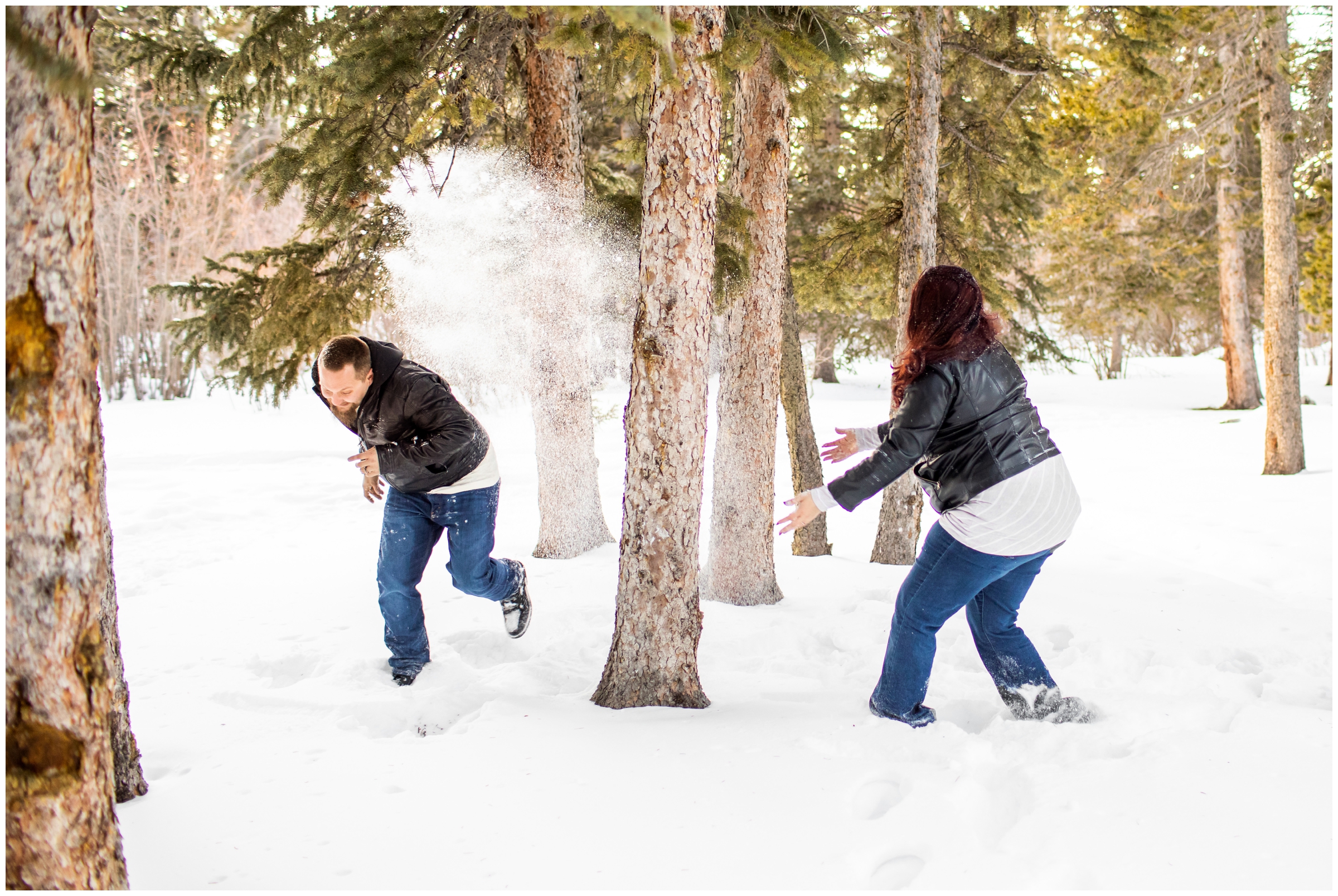 woman throwing snow at her fiancé during Colorado winter engagement photo shoot at Echo Lake 