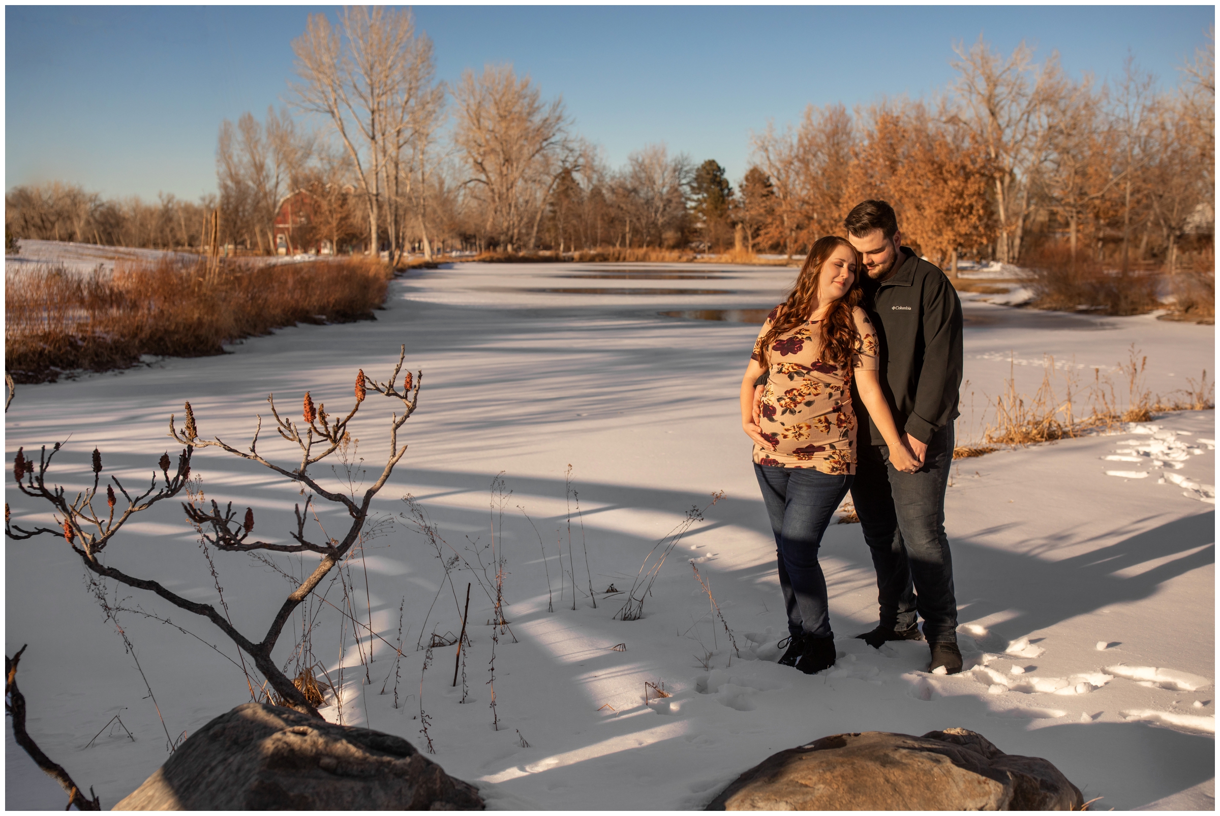 couple standing on frozen lake during Colorado winter maternity pictures at hudson Gardens