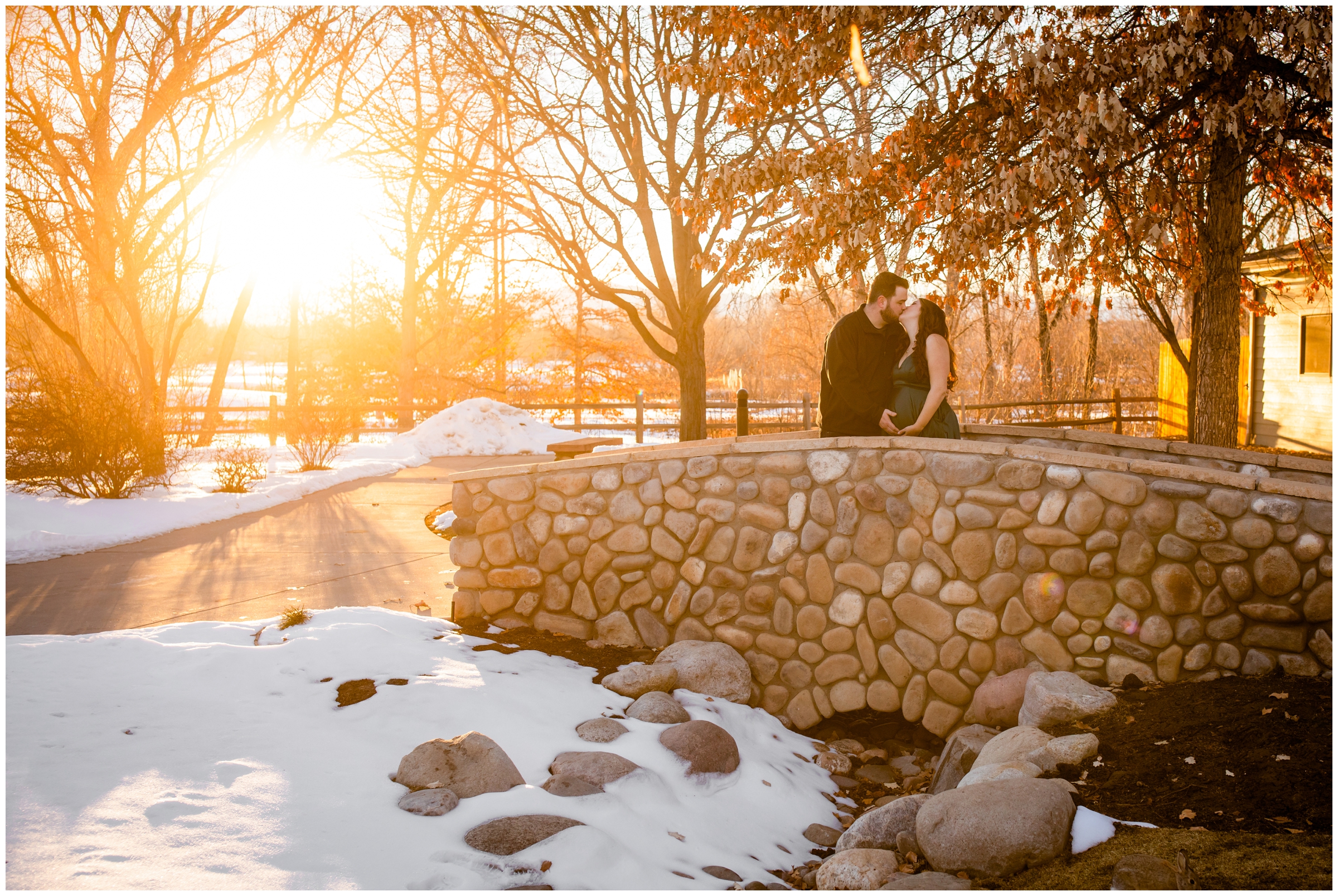couple kissing on a bridge at Hudson Gardens during winter maternity photos in Denver 