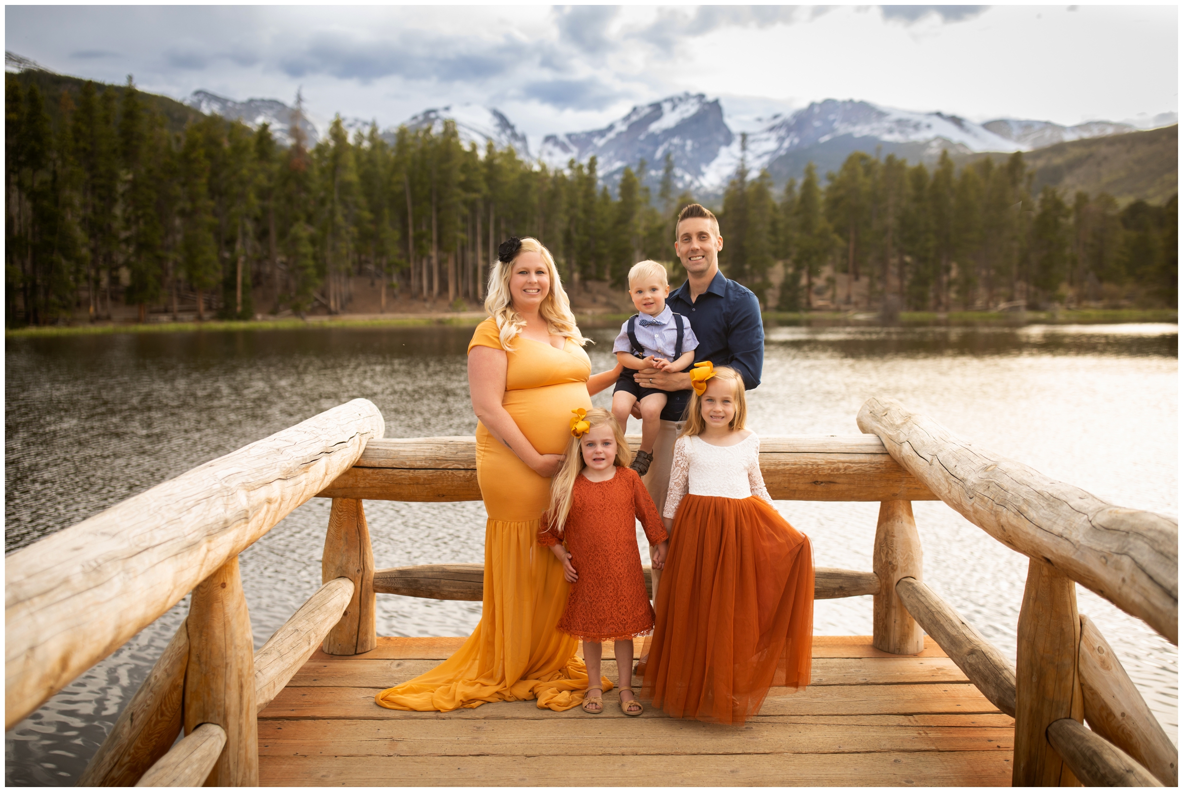 family posing on dock at Sprague Lake during Estes Park maternity portraits by Plum Pretty Photography 