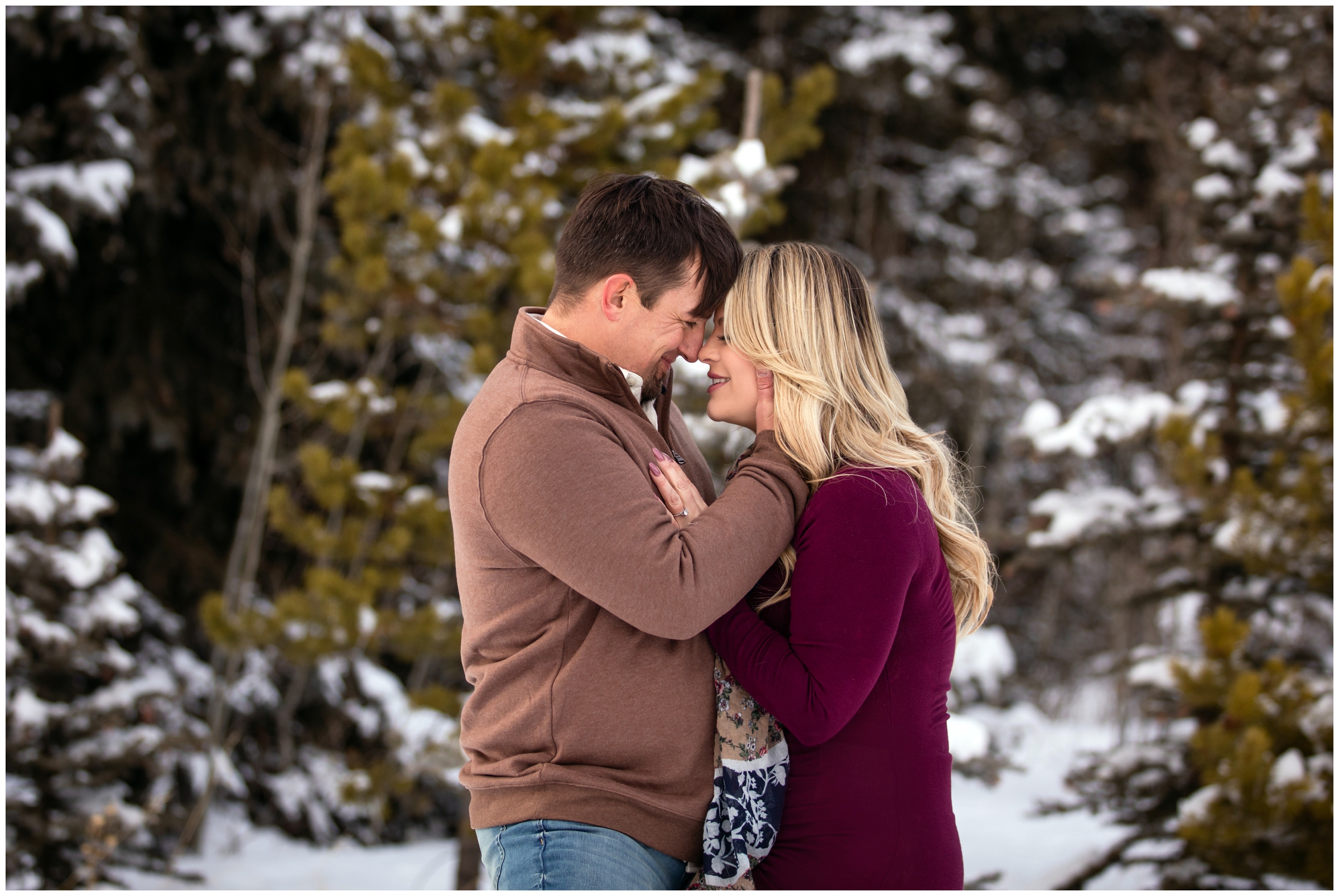 couple cuddling amongst snowy pine trees during Colorado winter engagement session