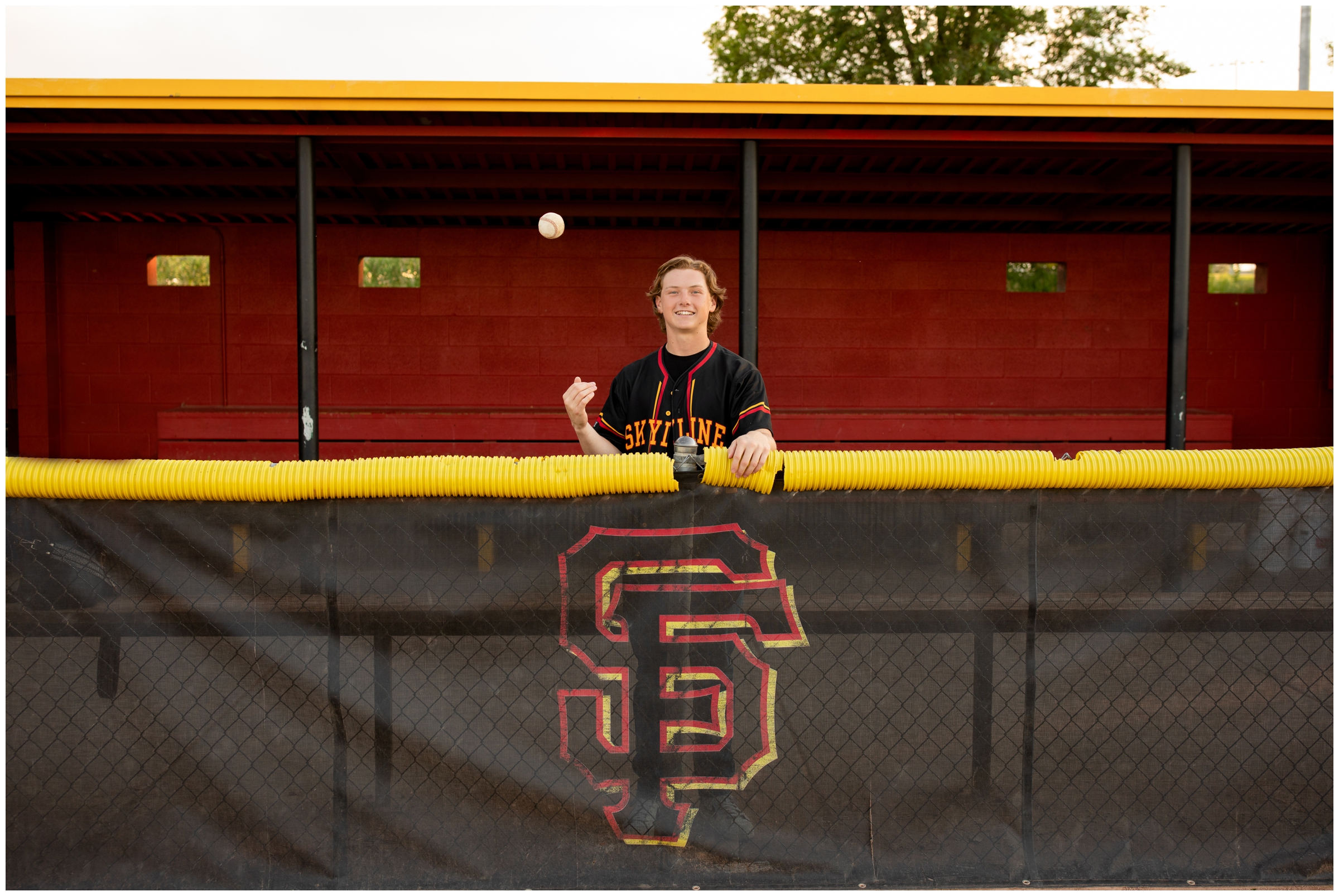 teen guy throwing baseball in the air during sports senior photography session at Skyline High School in Longmont Colorado
