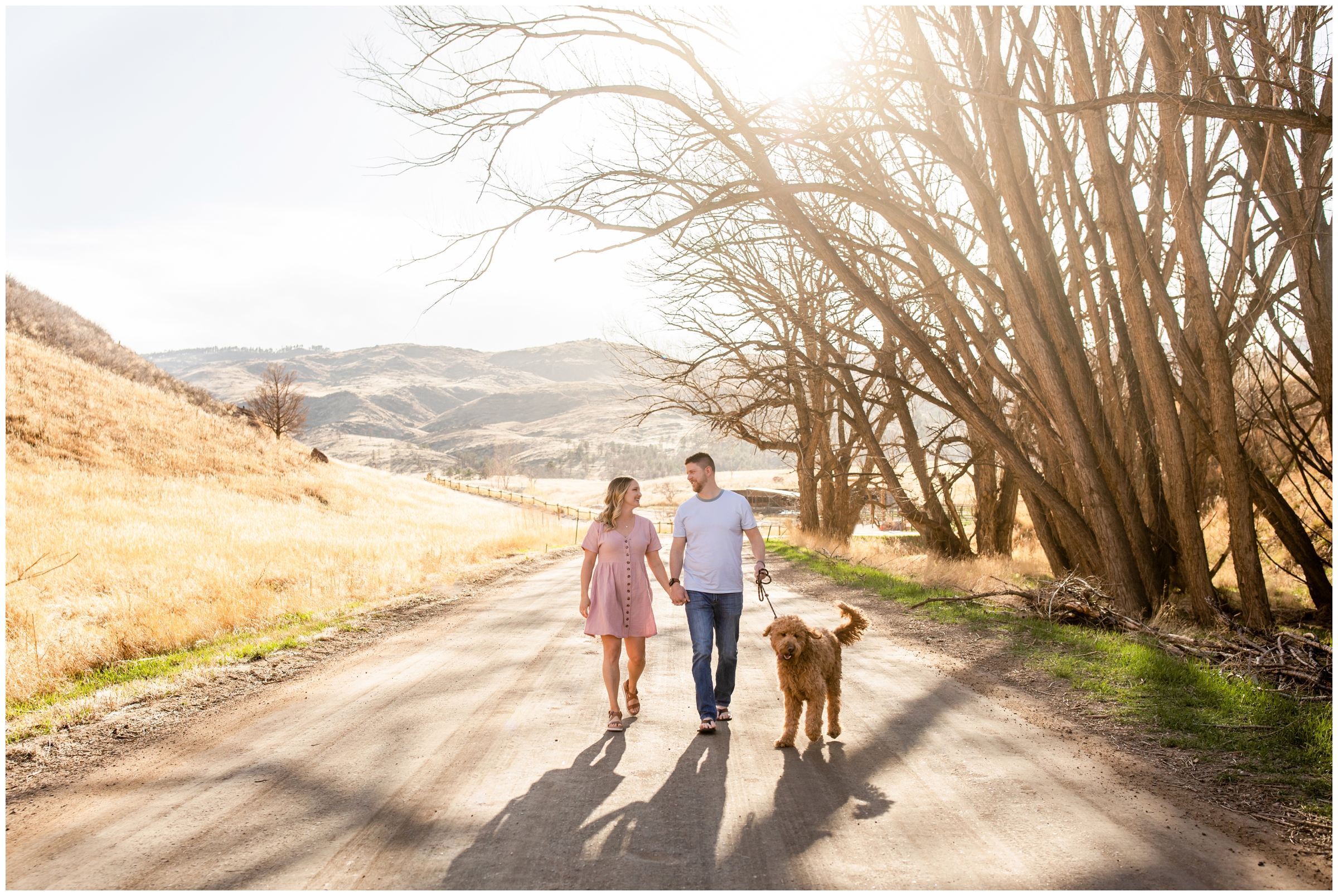 couple walking their dog during Fort Collins Colorado engagement pictures at bobcat ridge 