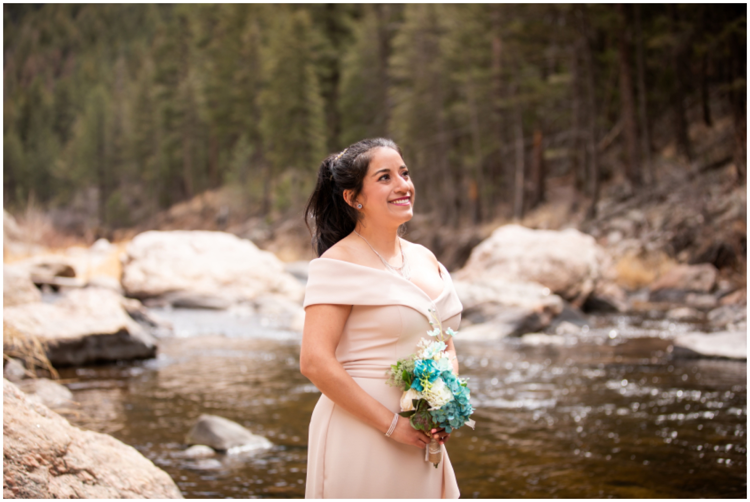 Colorado mountain bride in light pink dress posing next to the Big Thompson River
