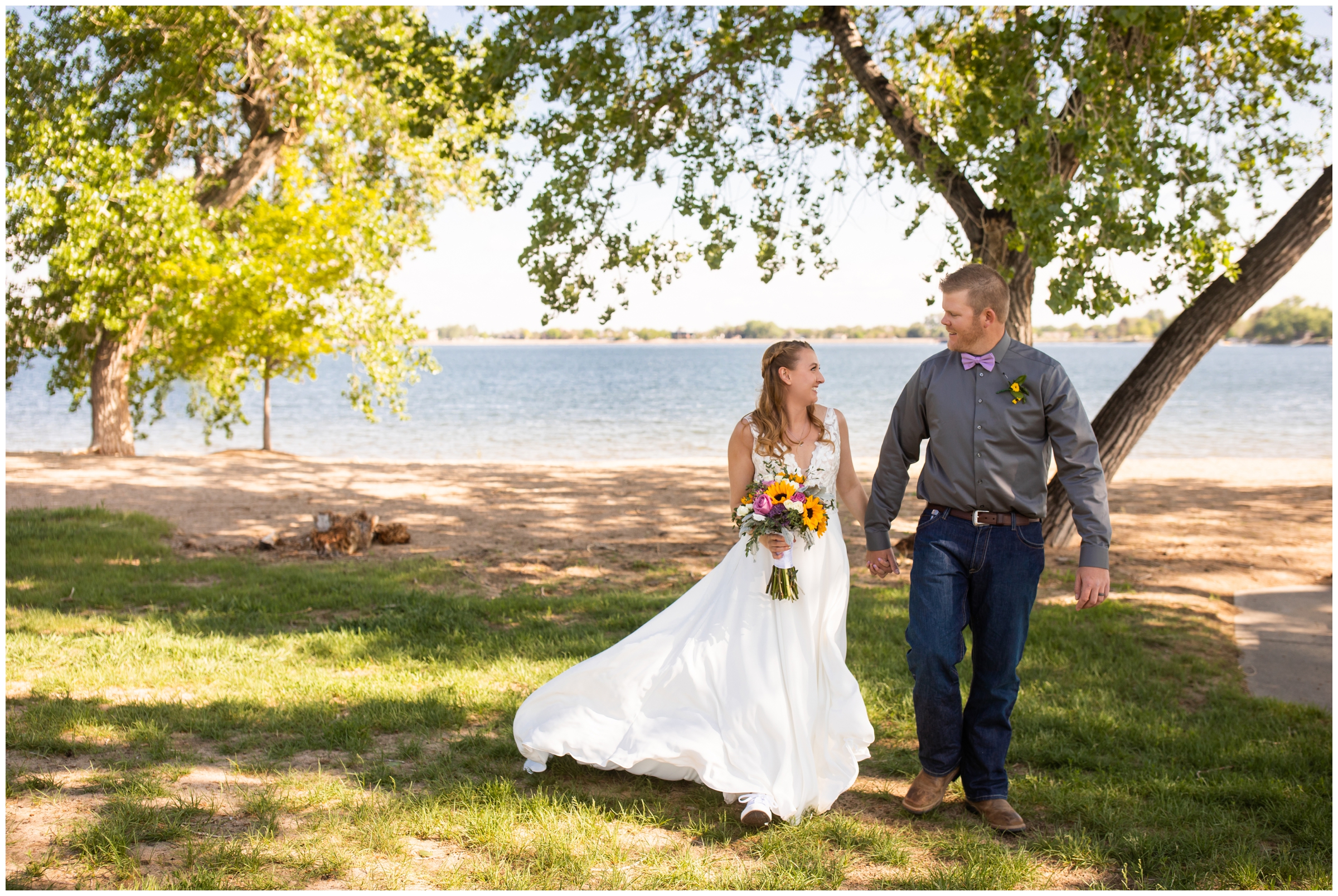 couple holding hands and walking during lake wedding pictures by Loveland Colorado wedding photographer Plum Pretty Photography 